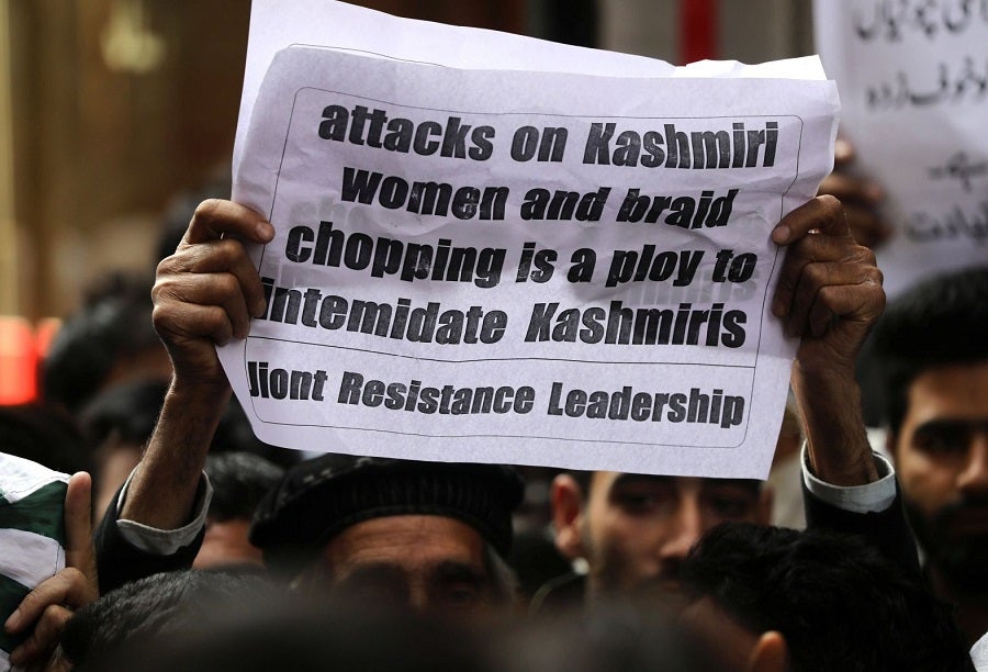 Activists of separatist groups hold placards during a protest against alleged braid chopping incidents in Srinagar