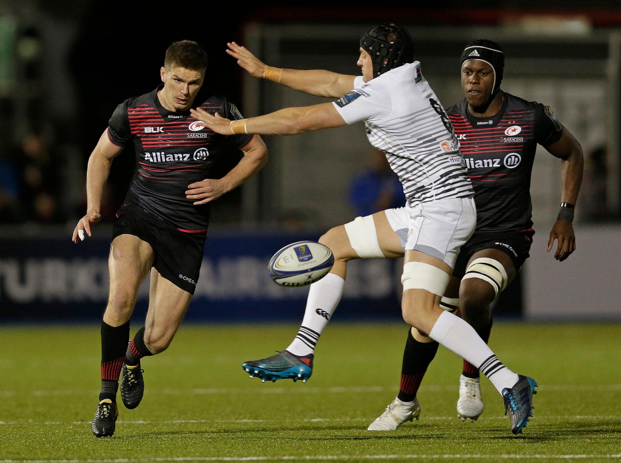 Owen Farrell of Saracens grubber kicks the ball beyond James King