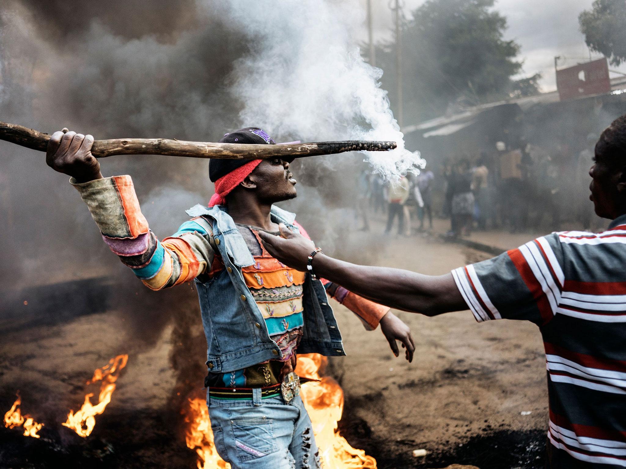 Opposition supporters demonstrate at a burning barricade during a protest in Kibera, Nairobi