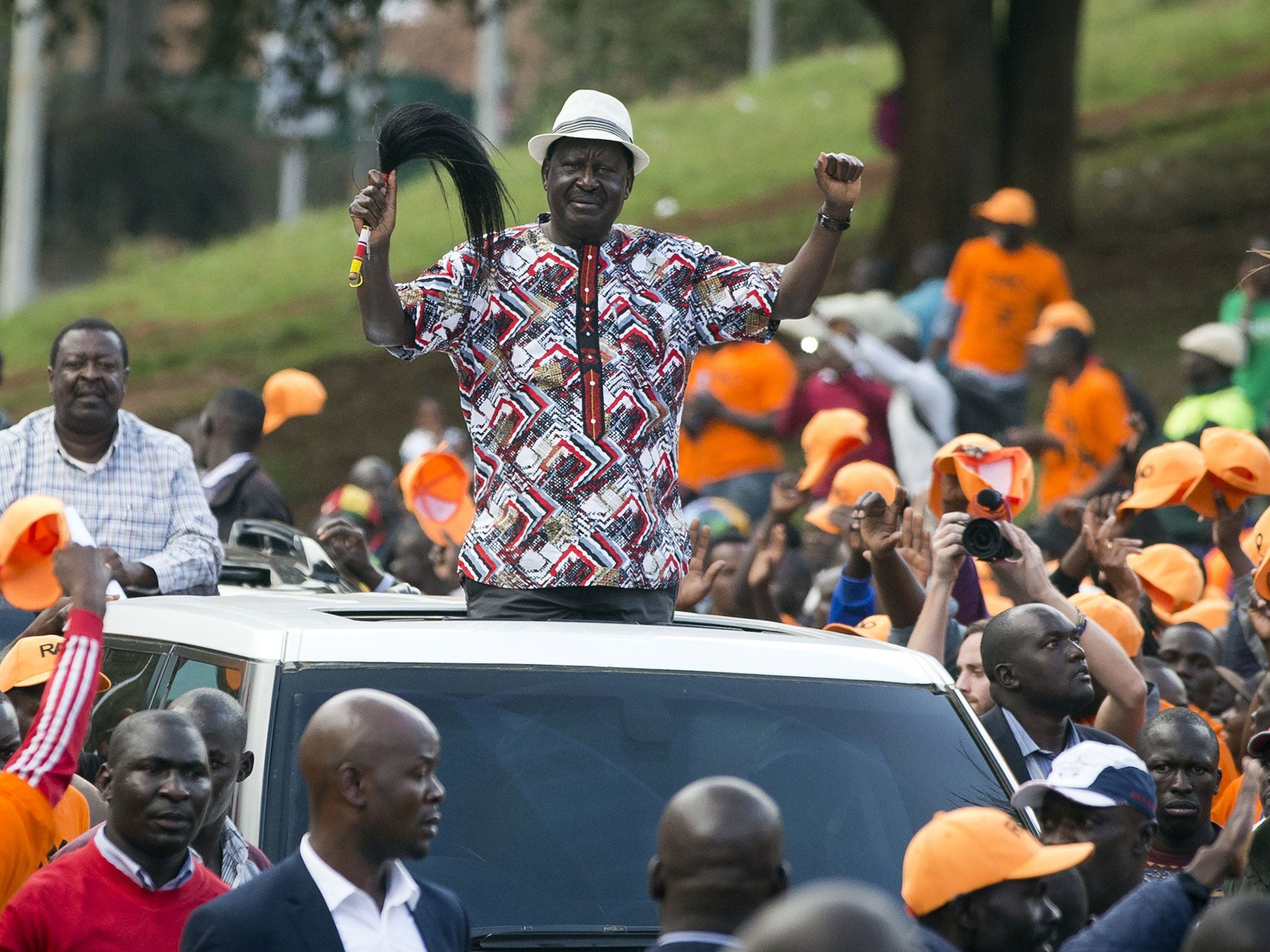 Kenyan opposition leader Raila Odinga greets the crowd as he arrives for as rally in the Uhuru Park in Nairobi