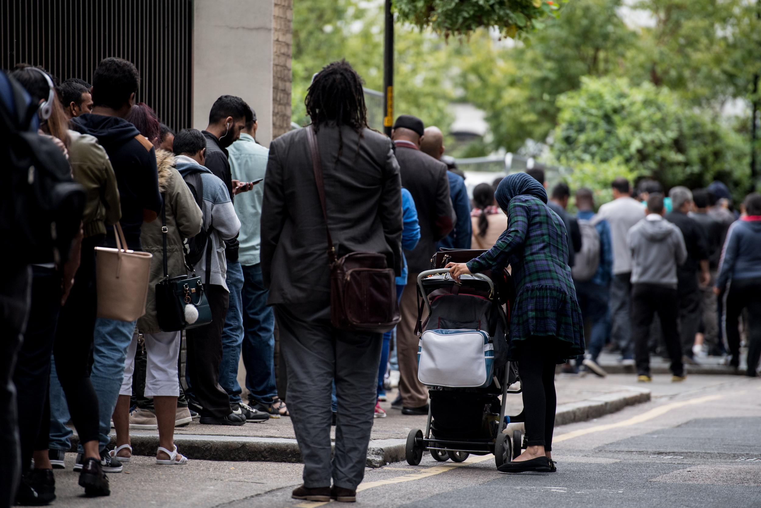 Immigrants queue around the Home Office building of Becket House in 2017