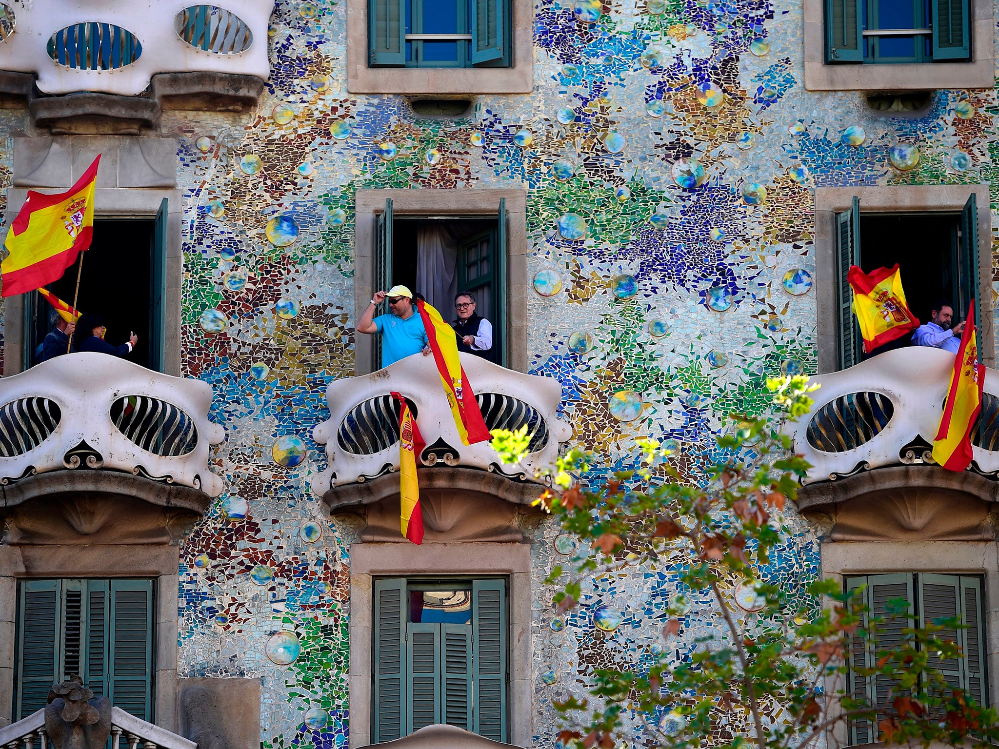 People waving Spanish flags from the Casa Batllo in Barcelona during an anti-independence rally. It is unclear how much support there is for declaring unilateral independence