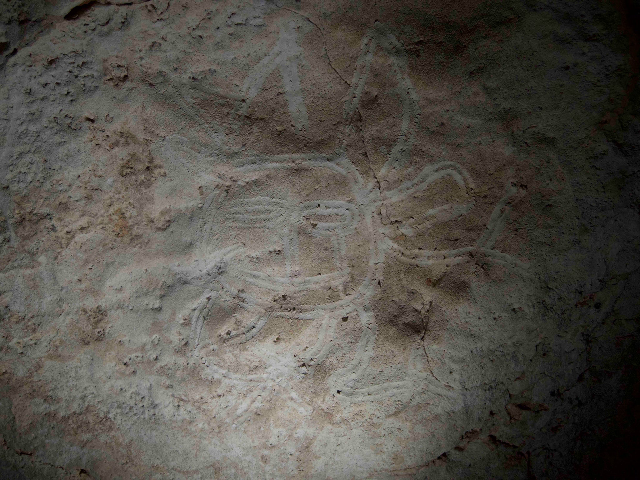 Finger-fluted “crying” face motif on cave wall