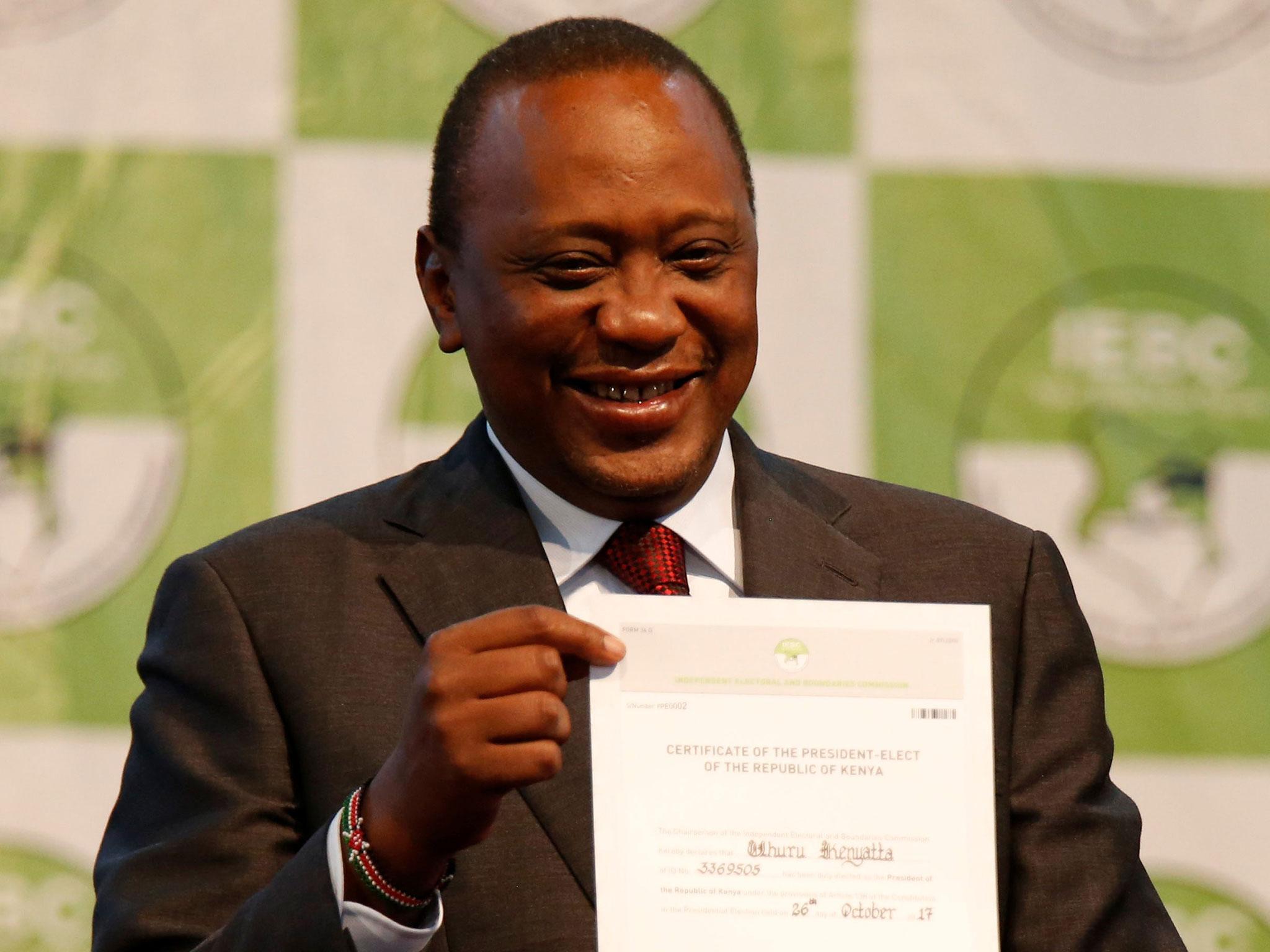 Incumbent President Uhuru Kenyatta holds the certificate of President-Elect of the Republic of Kenya after he was announced winner of the repeat presidential election at the IEBC National Tallying centre in Nairobi