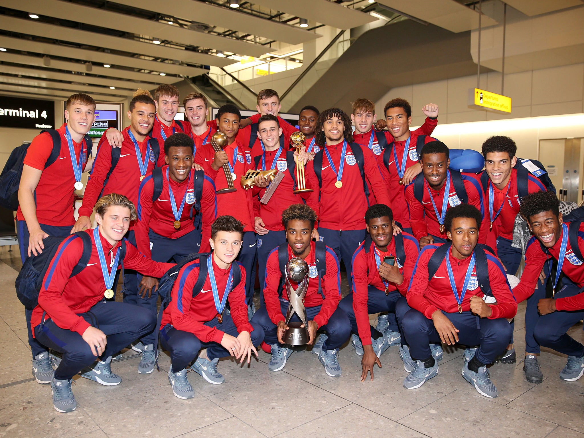 England's under 17's pose with the World Cup trophy as they arrive back to the UK