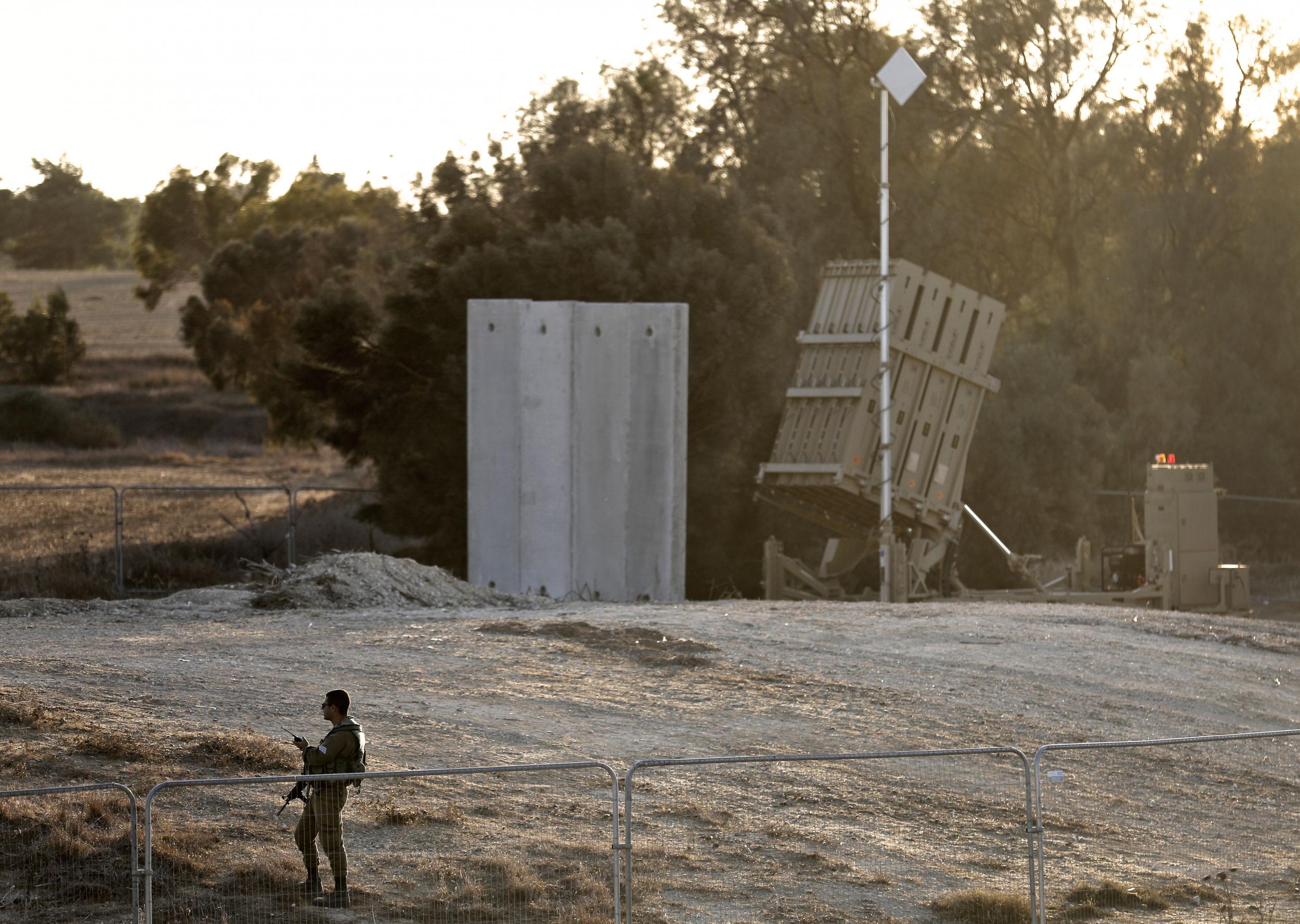 An Israeli soldier stands guard next to Israel's Iron Dome defence system, close to the border with the Gaza Strip near Kibbutz Kissufim in southern Israel, on 30 October 2017