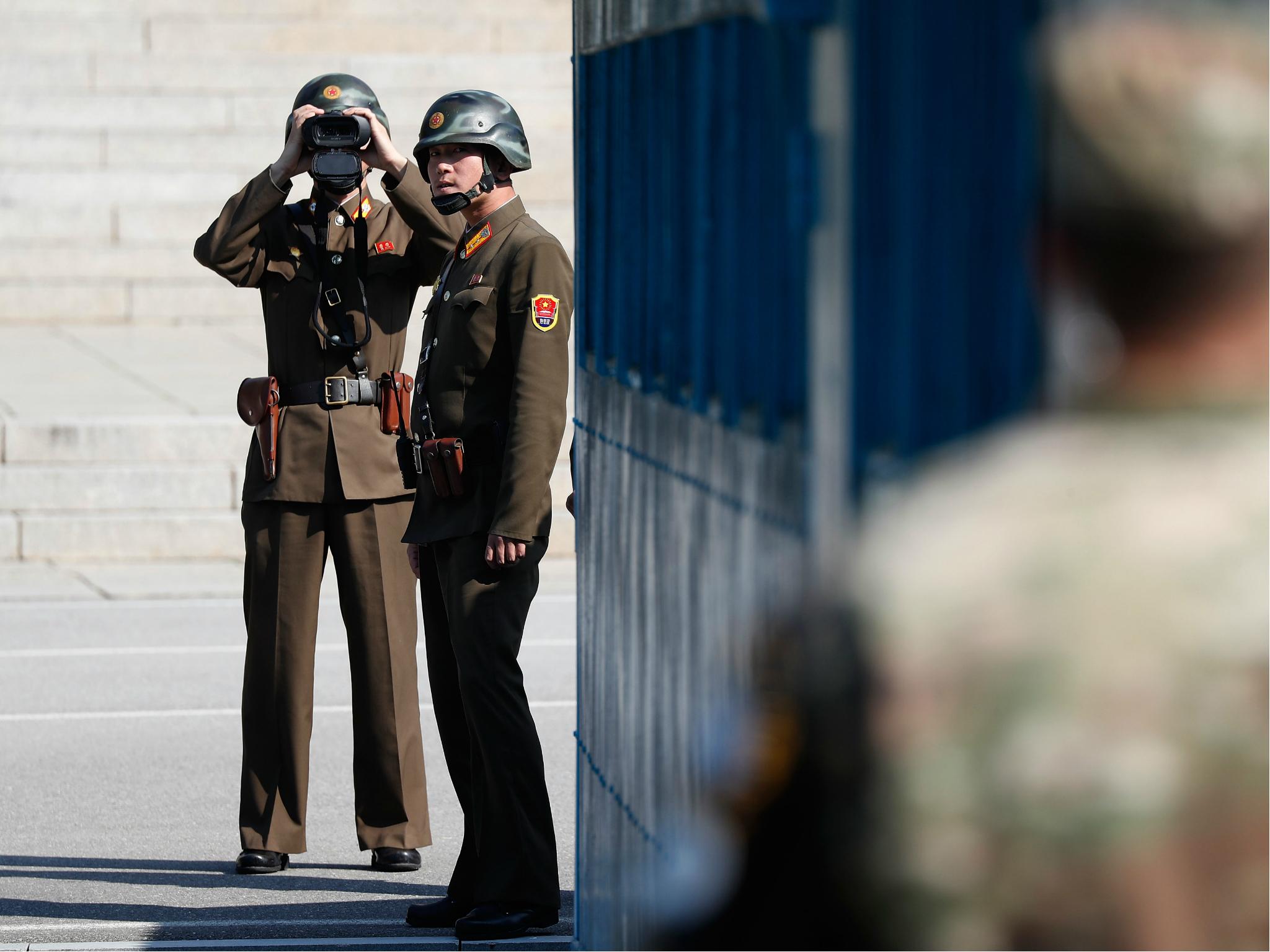 North Korean soldiers look at the South Korean side while US Defense Secretary Jim Mattis the Demilitarized Zone (DMZ) on 27 October 2017 in Panmunjom, South Korea.