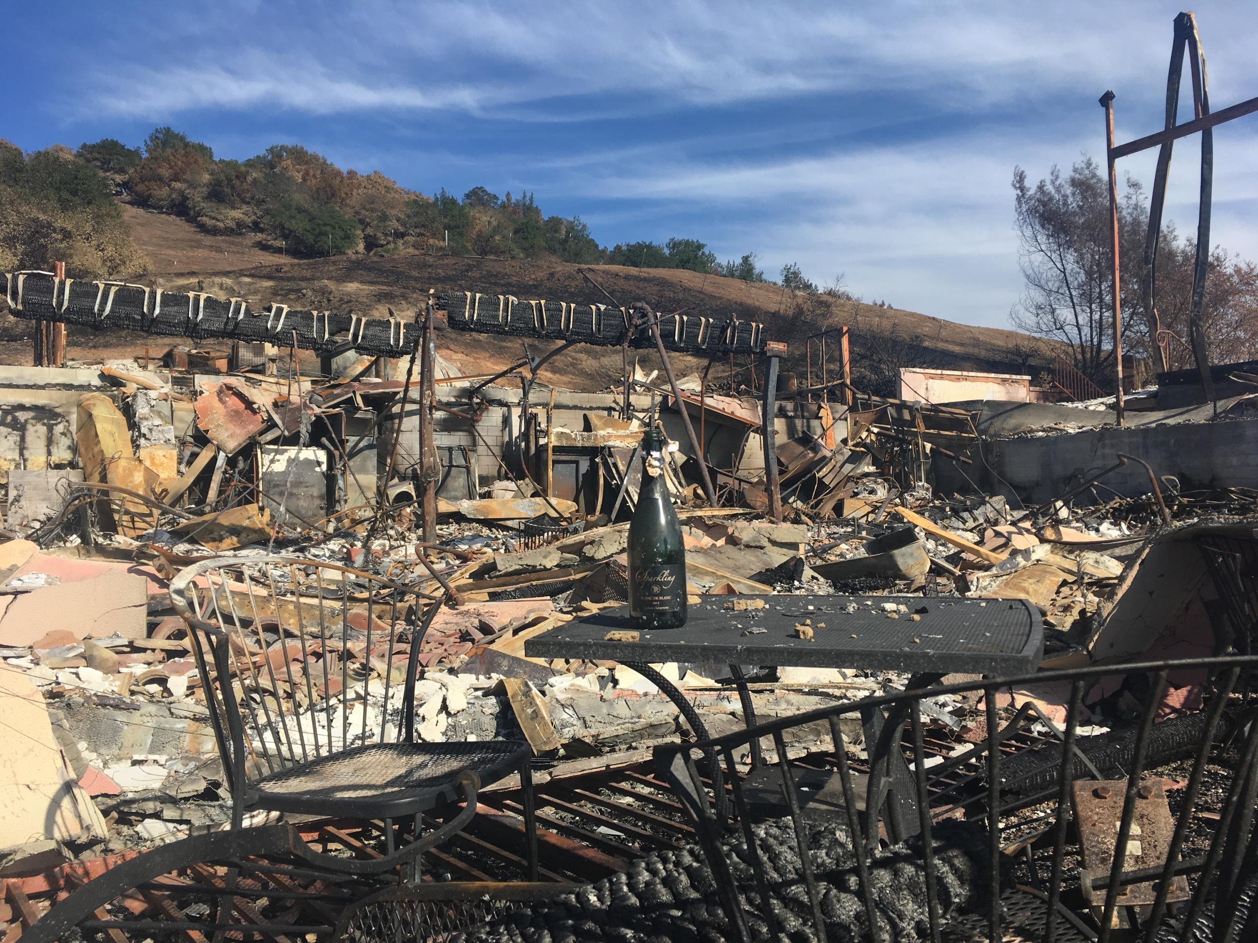 An empty bottle of wine stands in the ashes of the tasting and events centre at Paradise Ridge