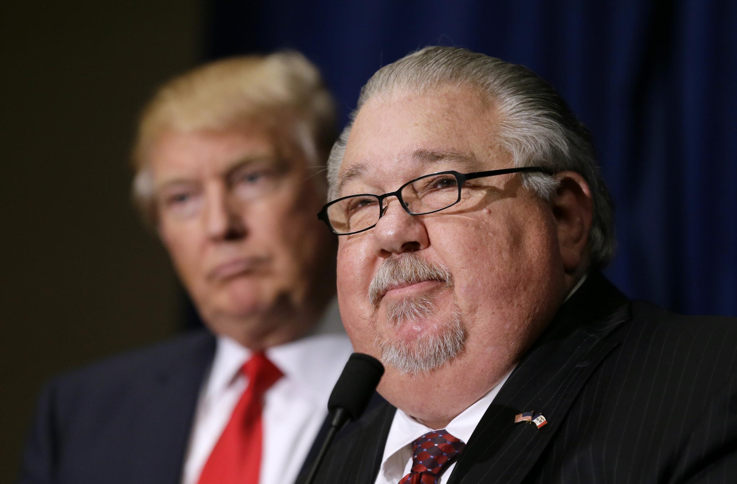 Sam Clovis speaks during a news conference as then-Republican presidential candidate Donald Trump watches