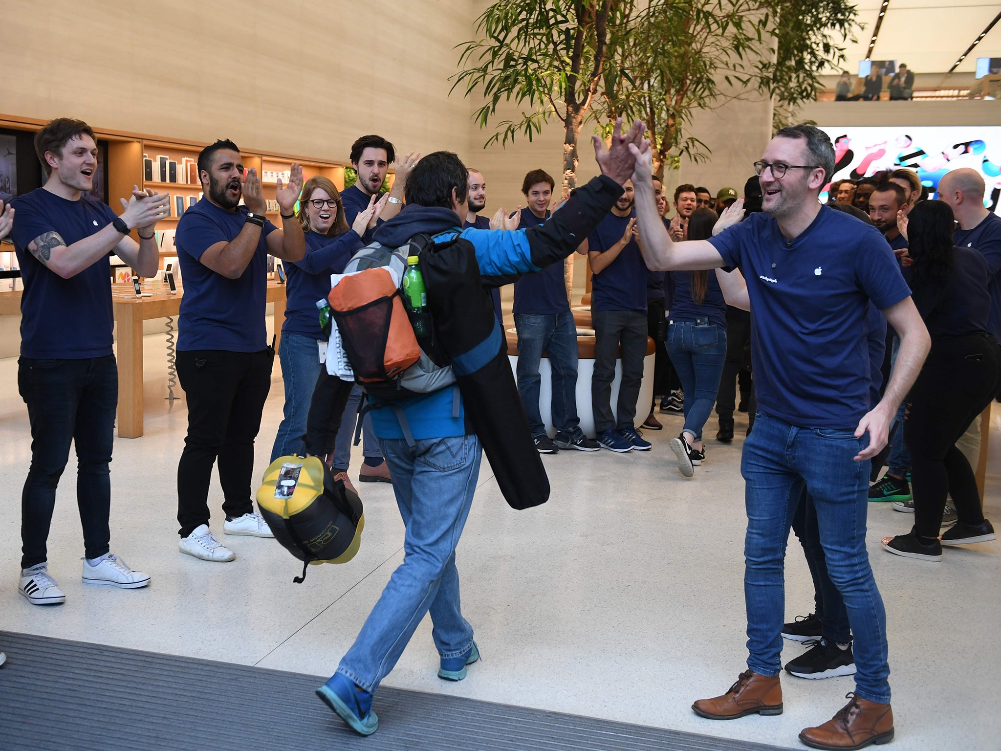 Apple staff congratulate customers as they are of the first to enter Apple's Regent Street store