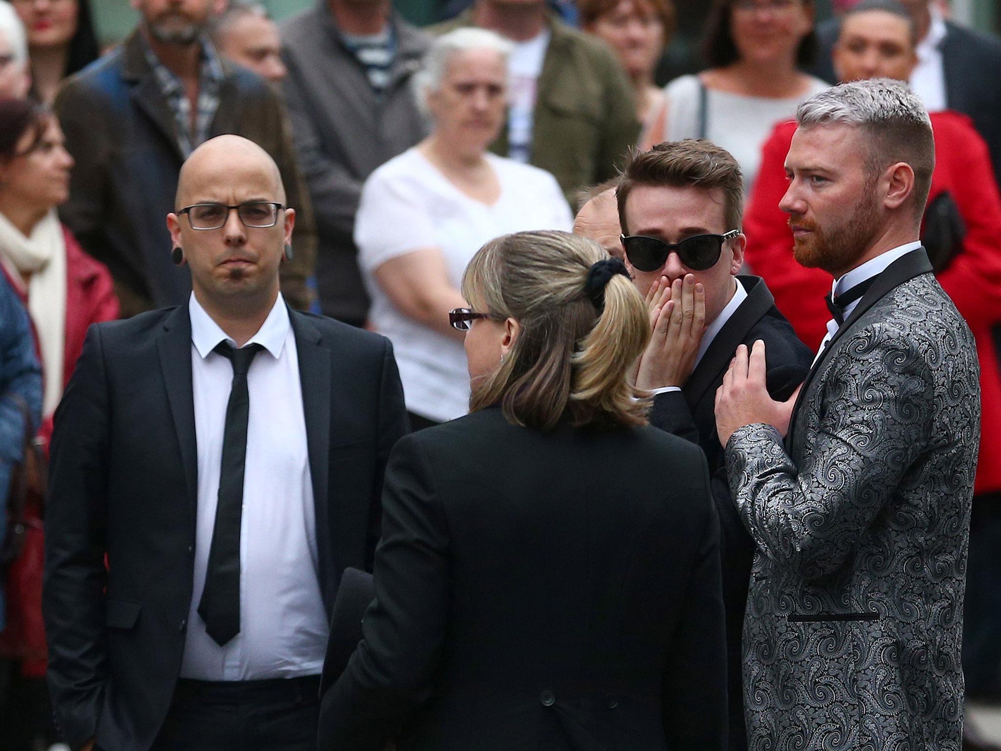 Dan Hett (left) with Martyn's partner Russell Hayward (2nd right) at his funeral at Stockport Town Hall in June