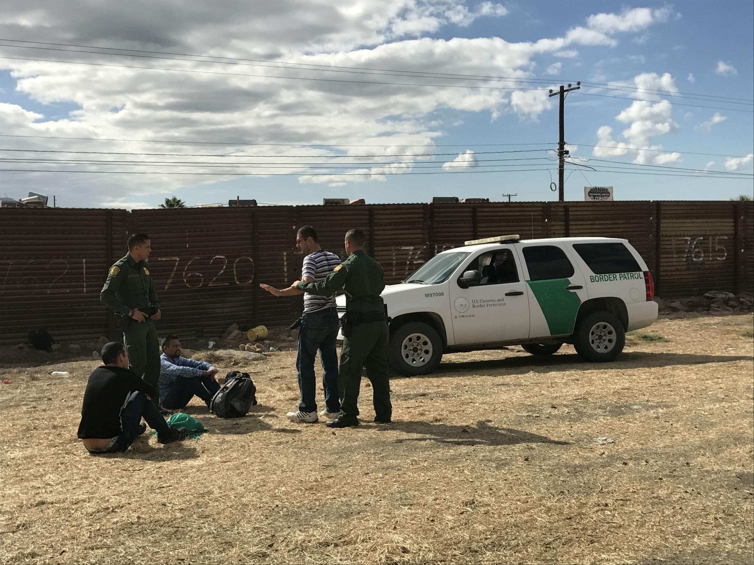 Migrants are apprehended moments after coming over the border wall from Tijuana to San Diego