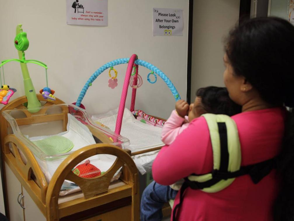 Indonesian domestic worker Anisa and her one-year-old daughter pose for a photo in Tai Kok Tsui, Hong Kong