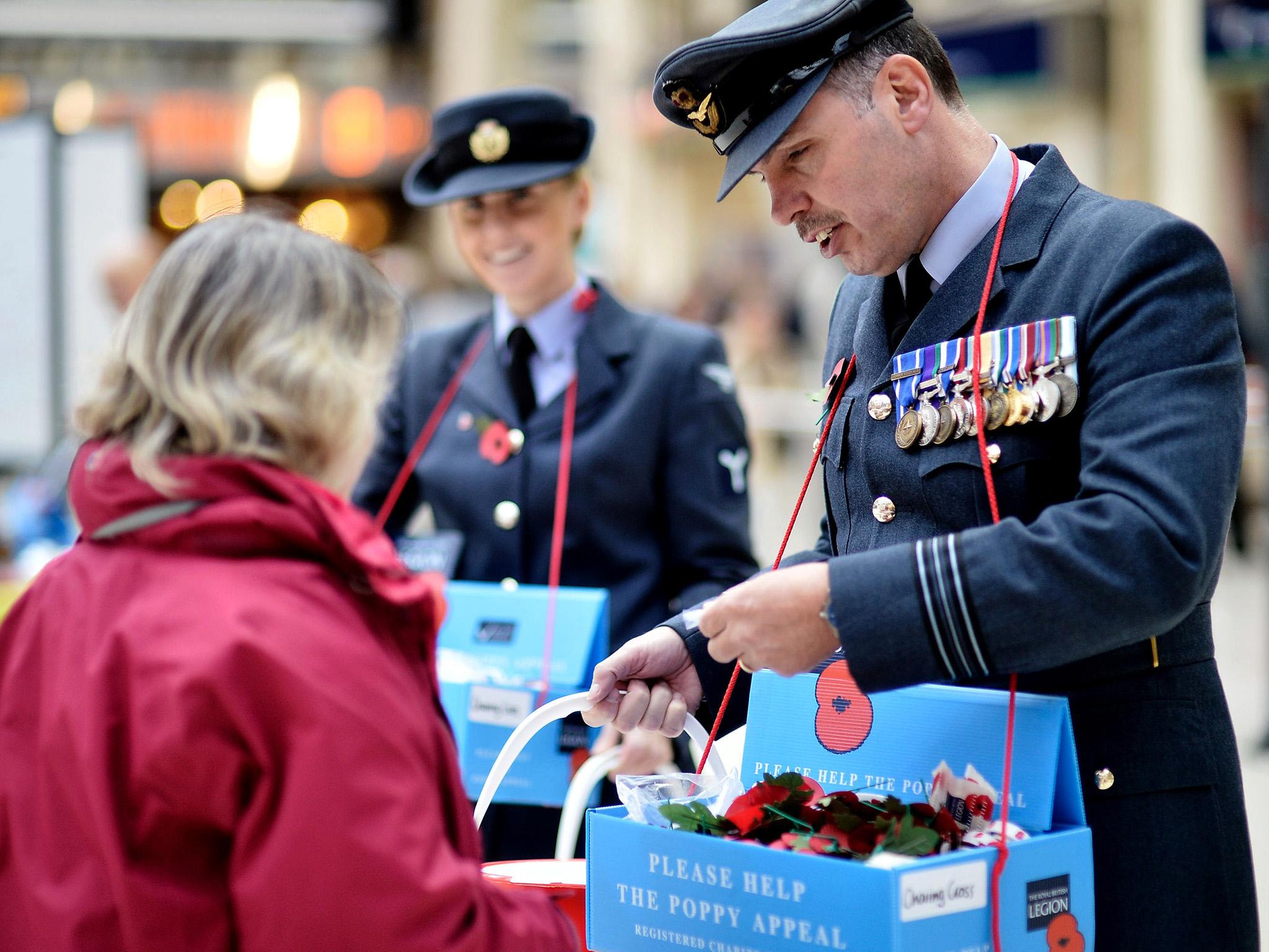 Members of the armed forces sell poppies at London’s Charing Cross station