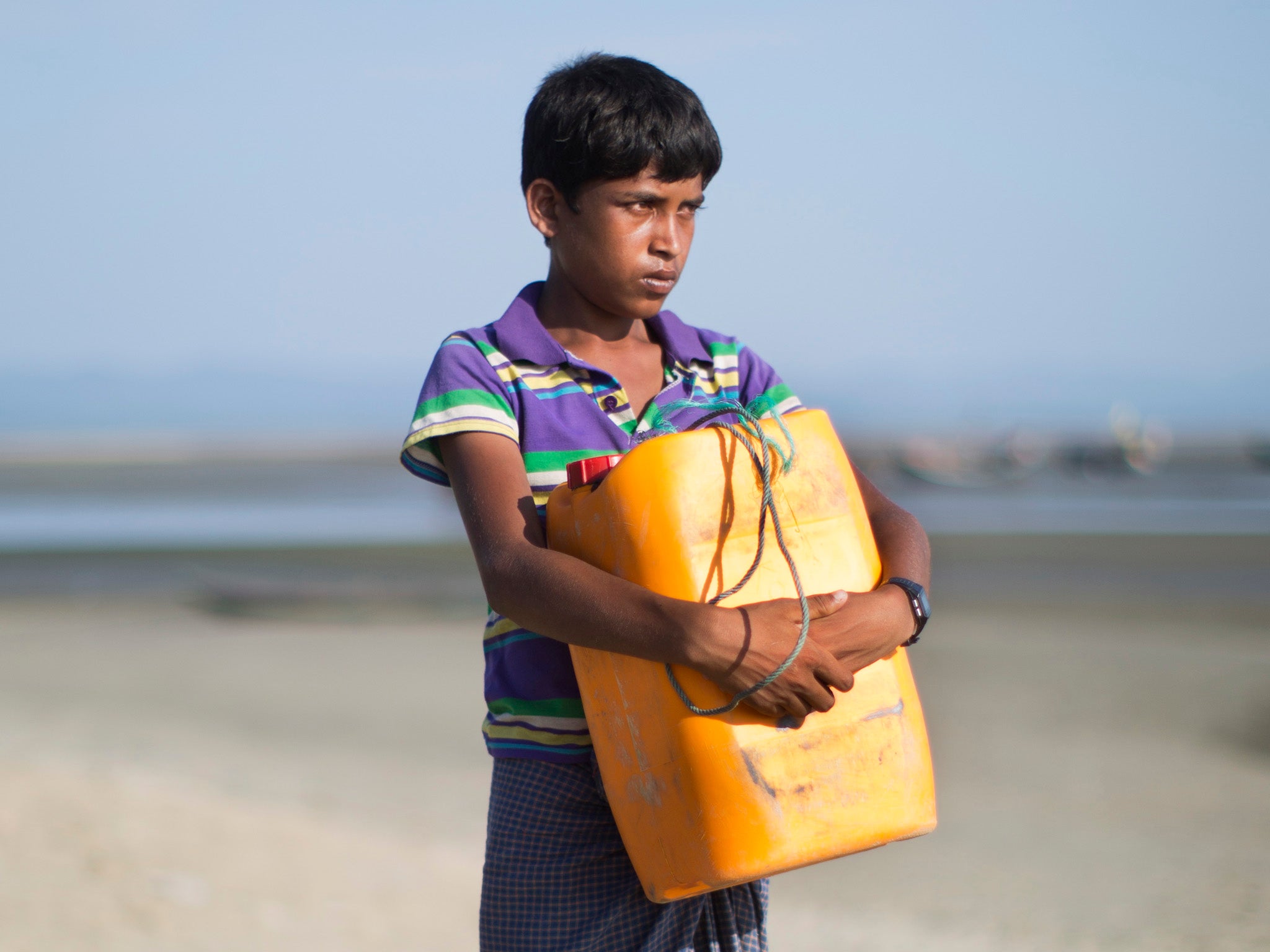 Nabi Hussain poses with the yellow plastic drum he used as a flotation device