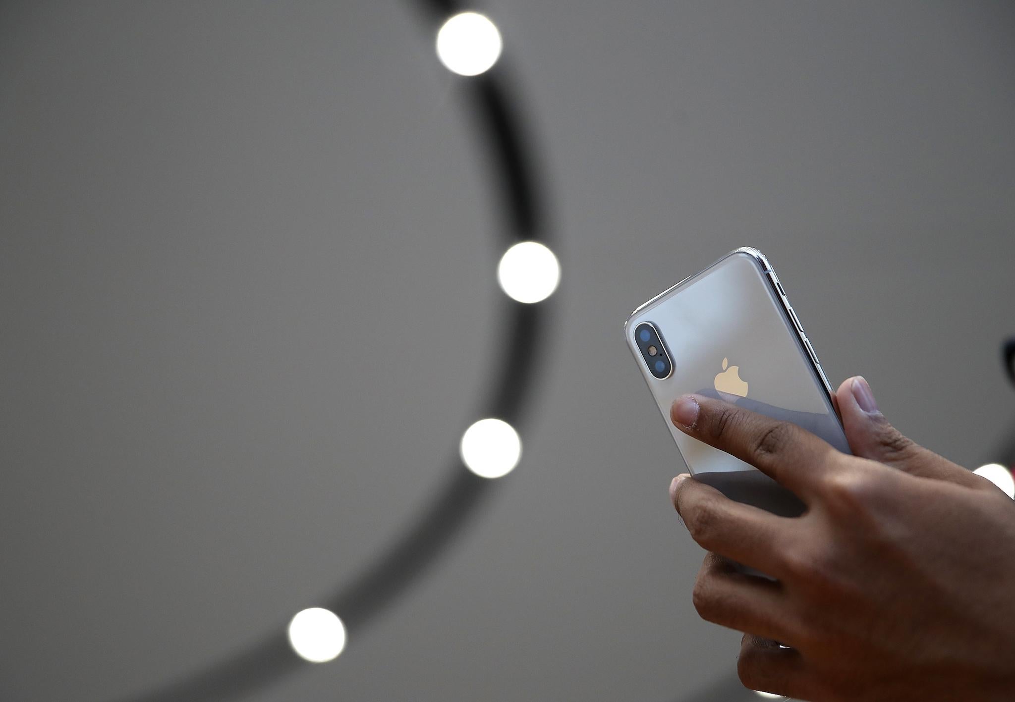 An attendee looks at a new iPhone X during an Apple special event at the Steve Jobs Theatre on the Apple Park campus on September 12, 2017 in Cupertino, California