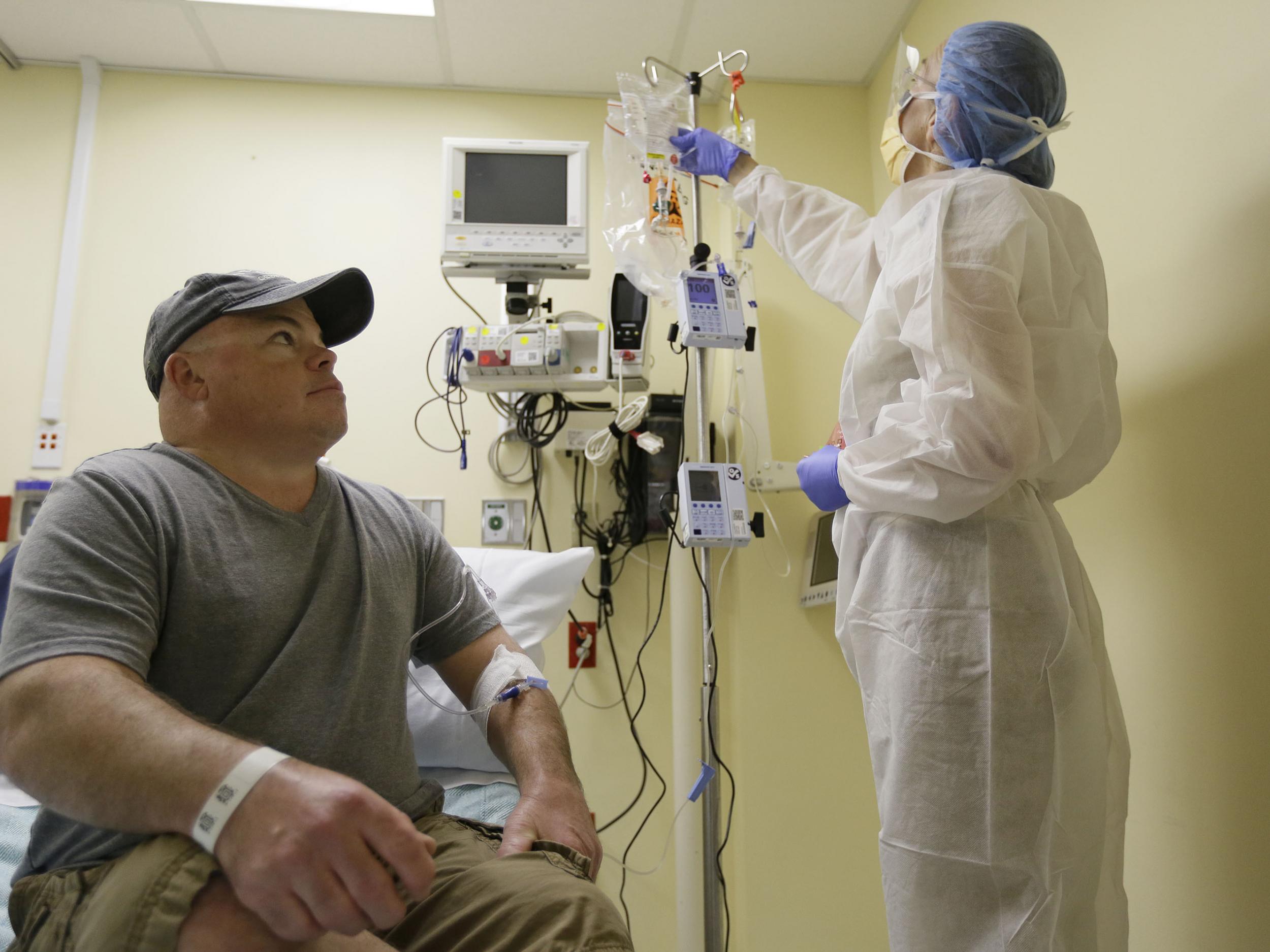 Brian Madeux, 44, looks up at nurse practitioner Jacqueline Madde while receiving the first human gene editing therapy at the UCSF Benioff Children's Hospital in Oakland, California