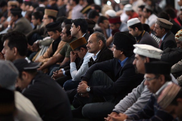 Muslim men listen to a speach by the Islamic Khalifa of the Ahmadiyya Muslim community