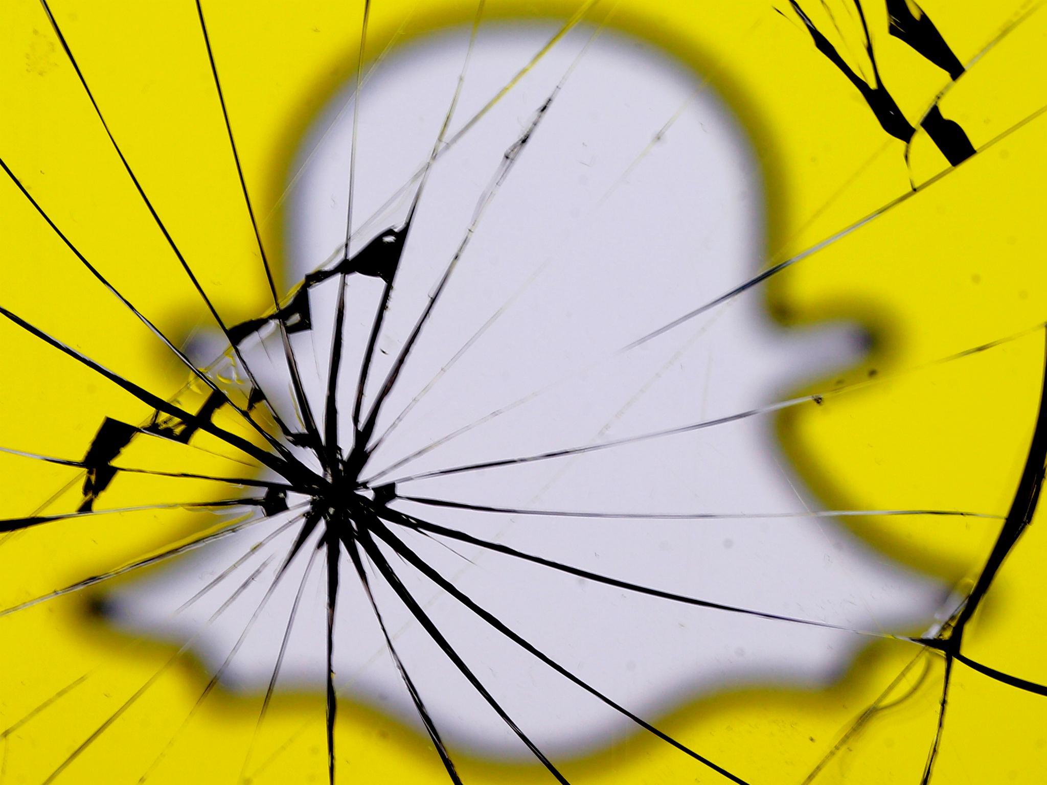 A Snapchat logo is seen through broken glass in this illustration picture, May 11, 2017