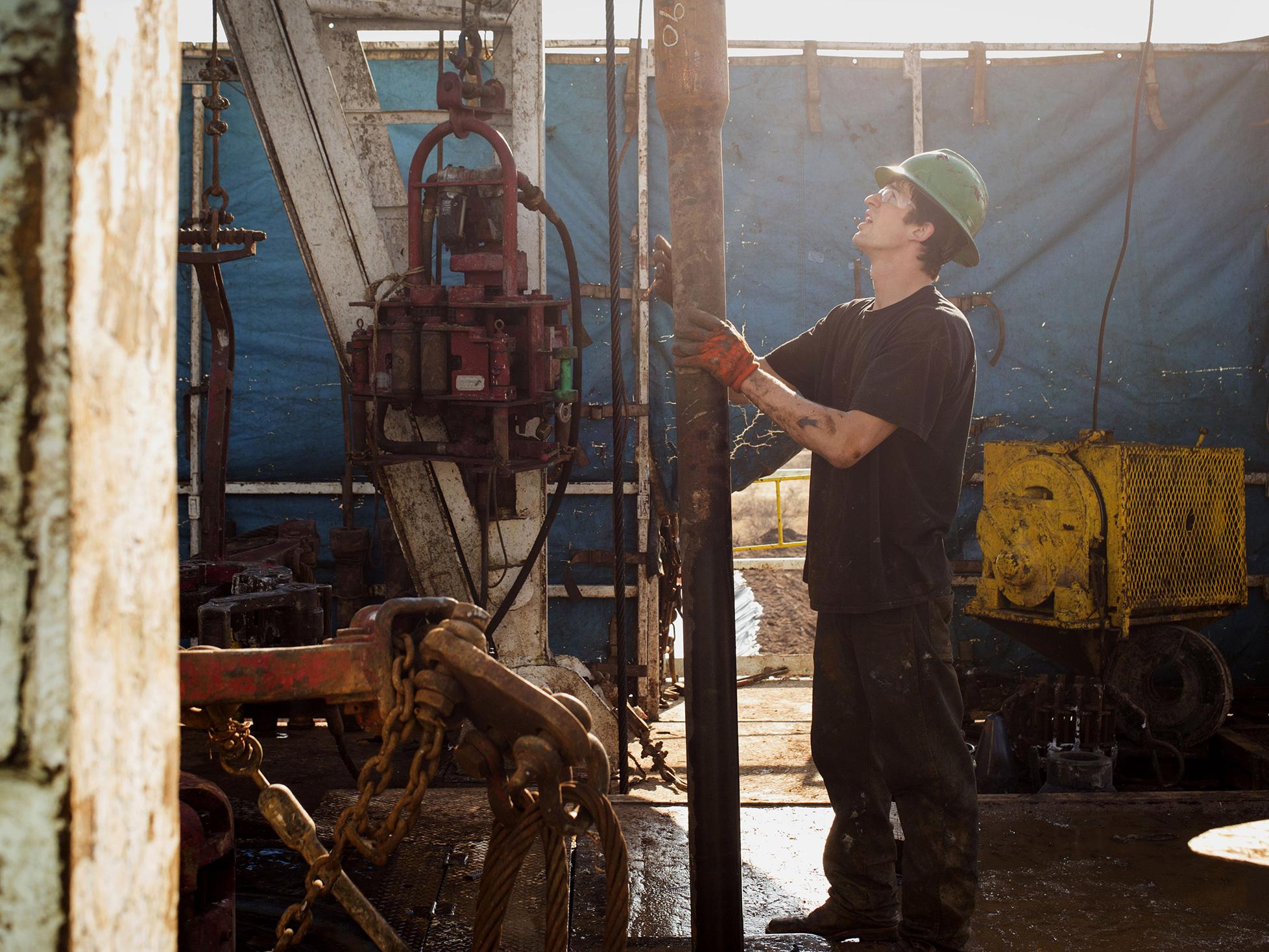 A worker checks the drilling rig before attaching it to the turntable on Endeavor Energy Resources's Big Dog Drilling Rig 22 in the Permian basin outside of Midland, Texas