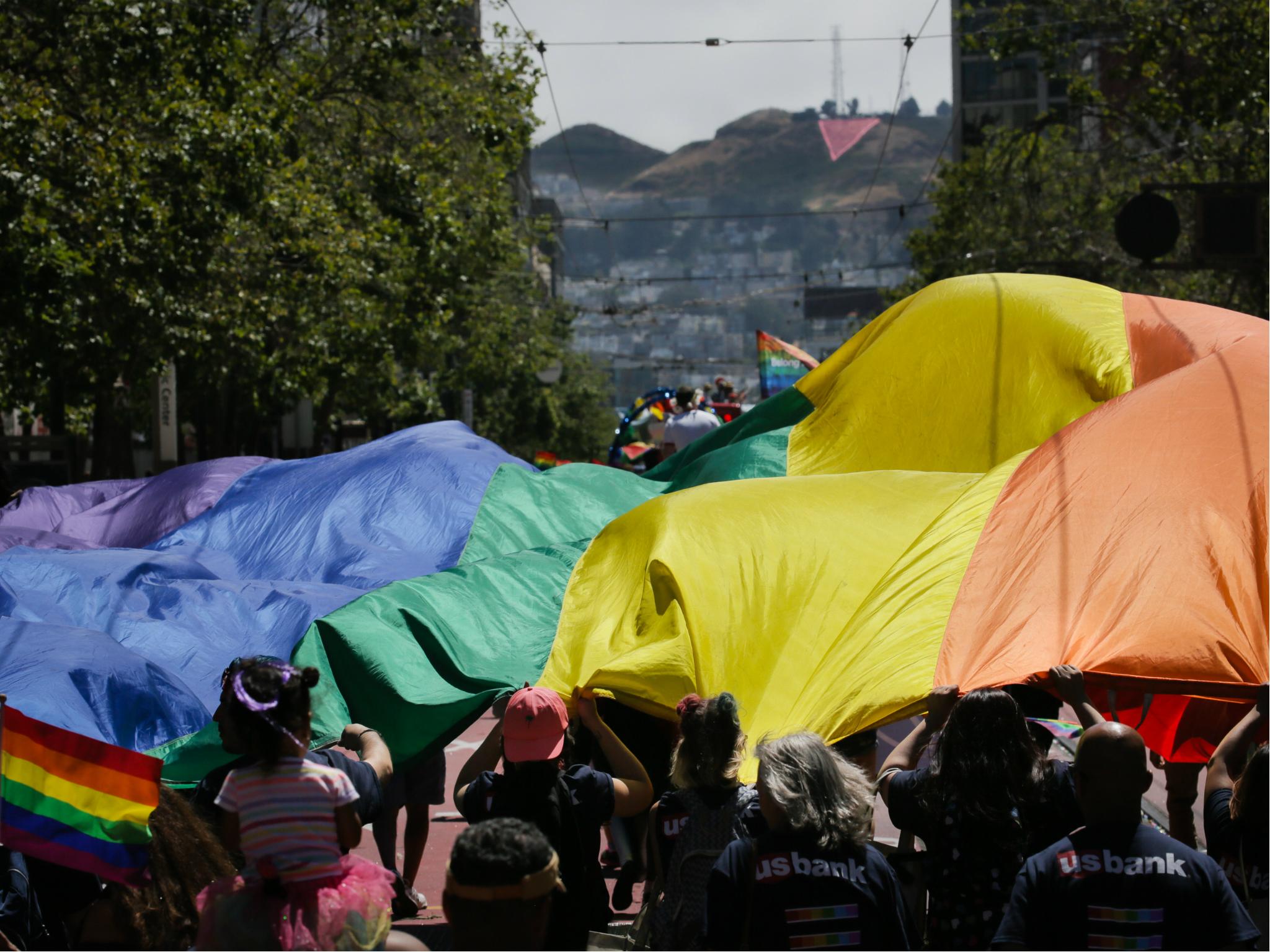 A group of marchers hold a giant rainbow flag while participating in the annual LGBTQI Pride Parade on 25 June 2017 in San Francisco, California.