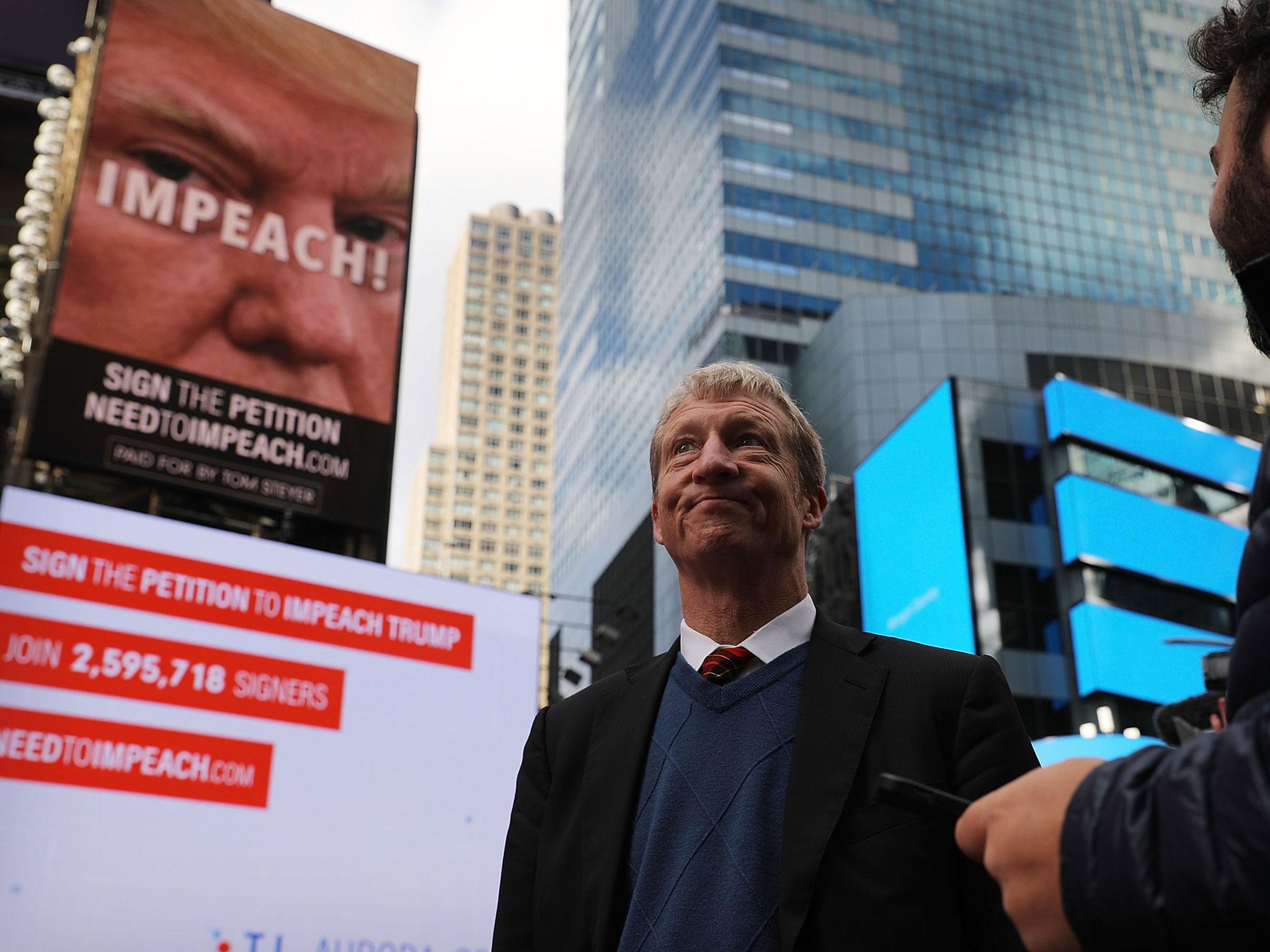 Tom Steyer stands in front of one of the billboards he has funded in Times Square calling for the impeachment of President Donald Trump