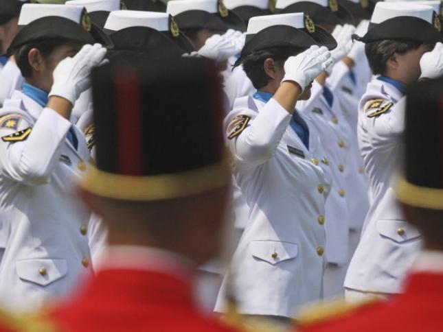 Indonesian police officers salute on parade