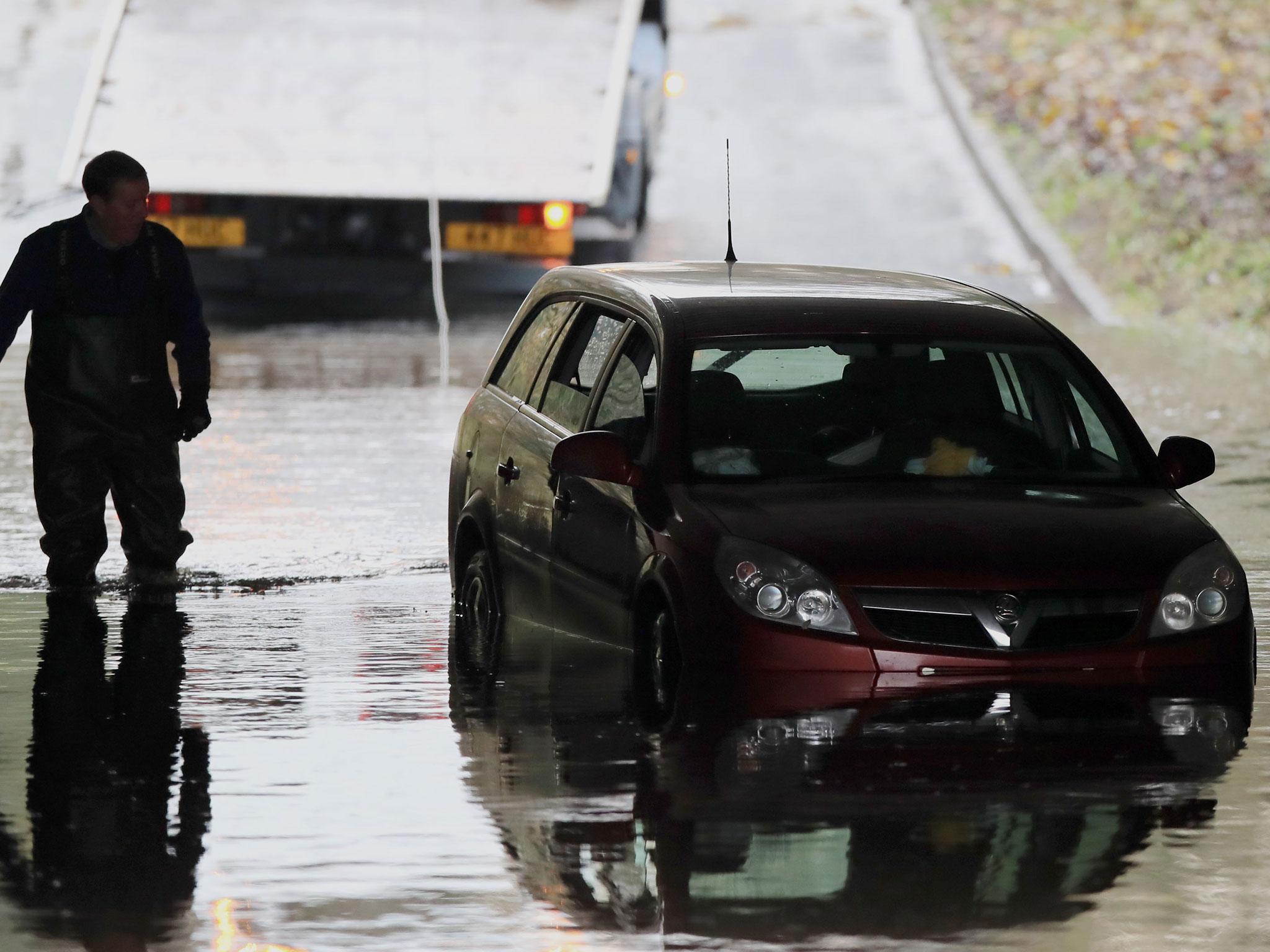 A car stuck in flood water under a bridge in Galgate, Lancashire, as heavy rain caused widespread flooding and travel disruption across north-west England and North Wales