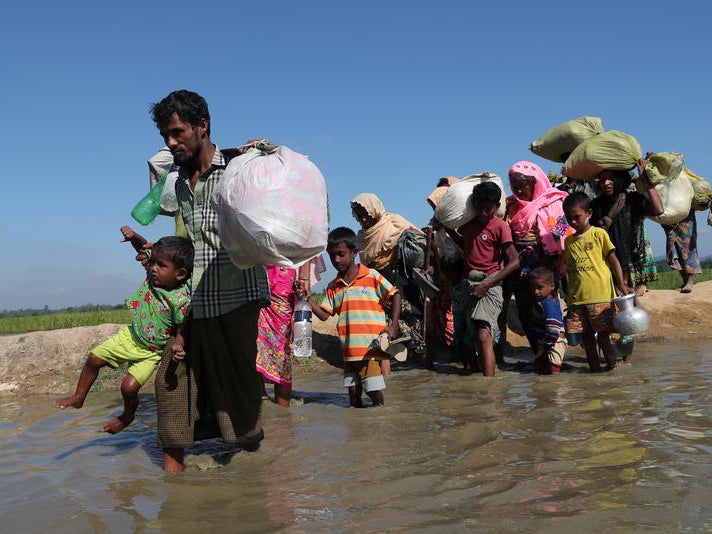 Rohingya refugees walk towards a refugee camp after crossing the border in Anjuman Para near Cox's Bazar, Bangladesh