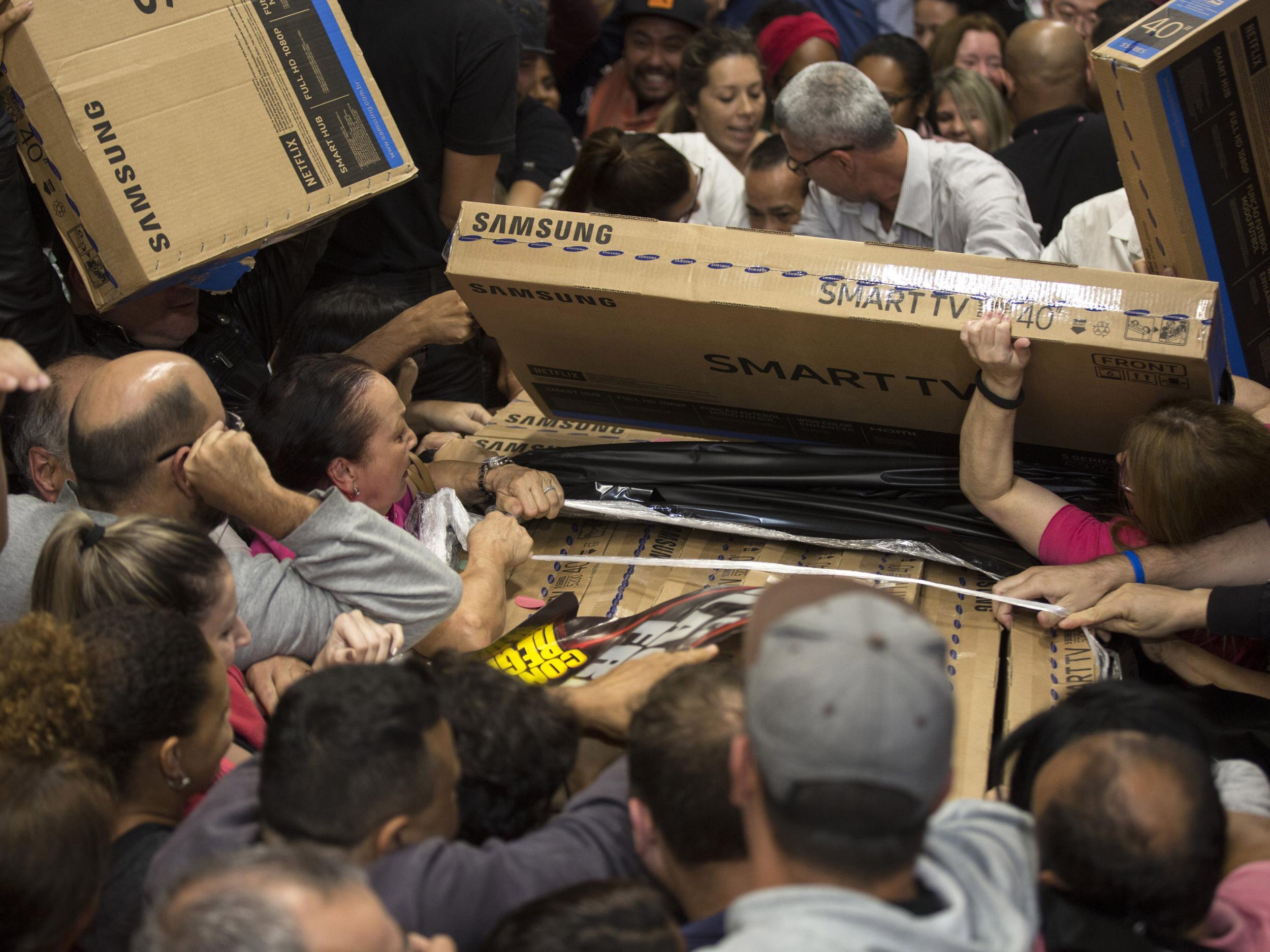 Dozens of Brazilians reach for television sets in a storeinf Sao Paulo