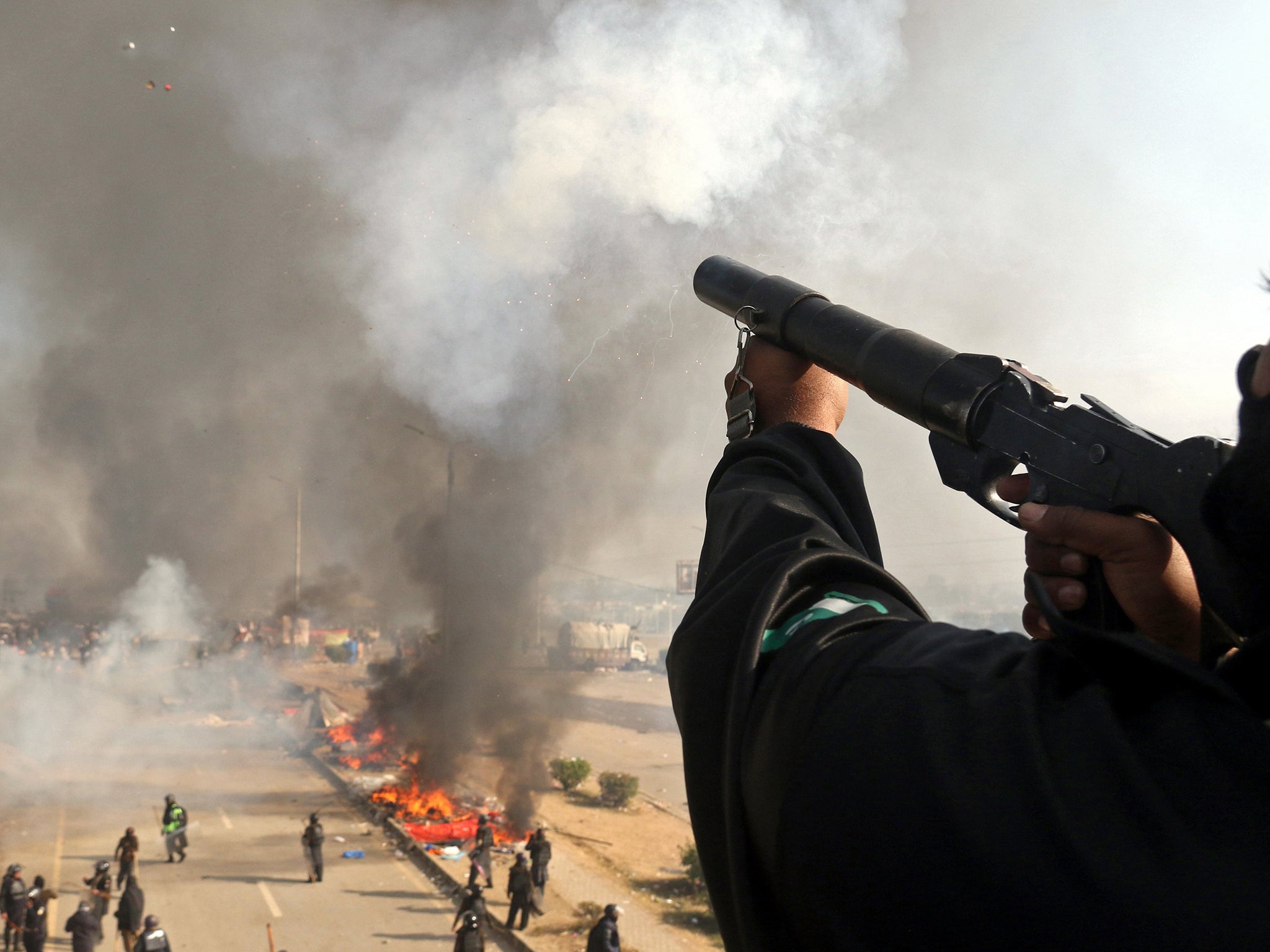 Pakistani police try to disperse protesters who have been blocking main roads for weeks