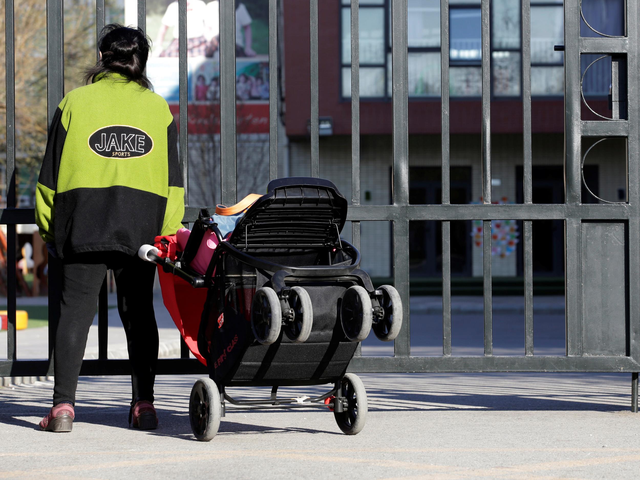 A woman stands outside the gate at RYB Education – whose staff are being investigated by police over alleged mistreatment