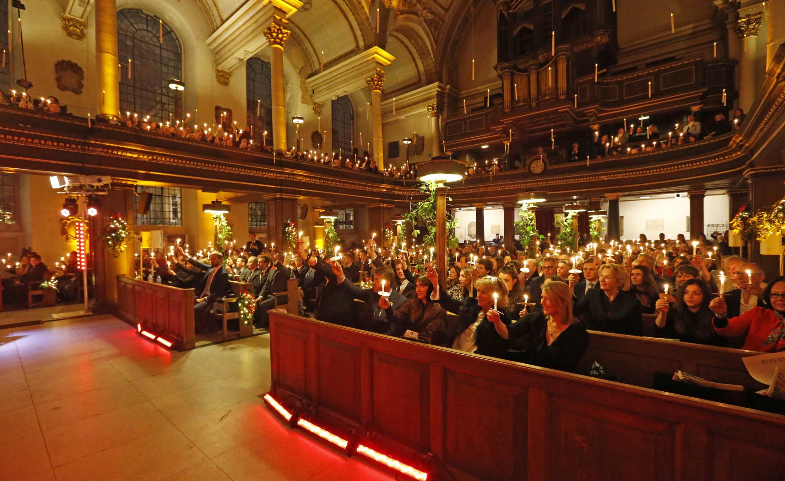 Congregation raises their candles in the air in show of peace at the Fayre of St James