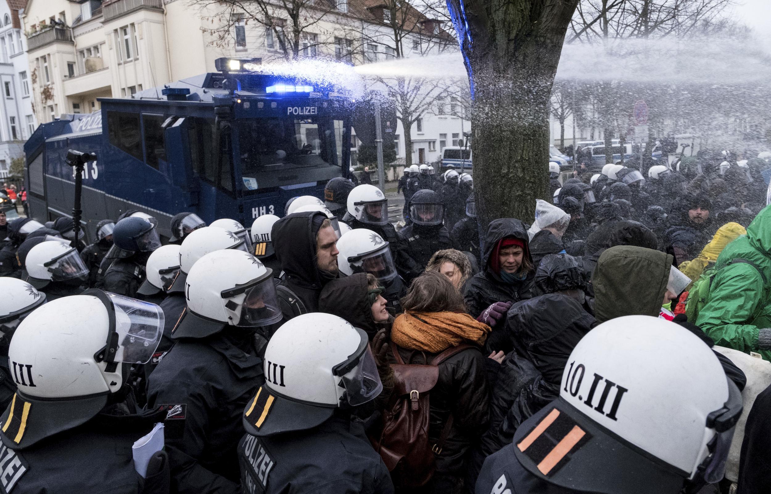 Police use a water cannon to clear a street blocked by demonstrators near the venue of the AfD convention in Hanover