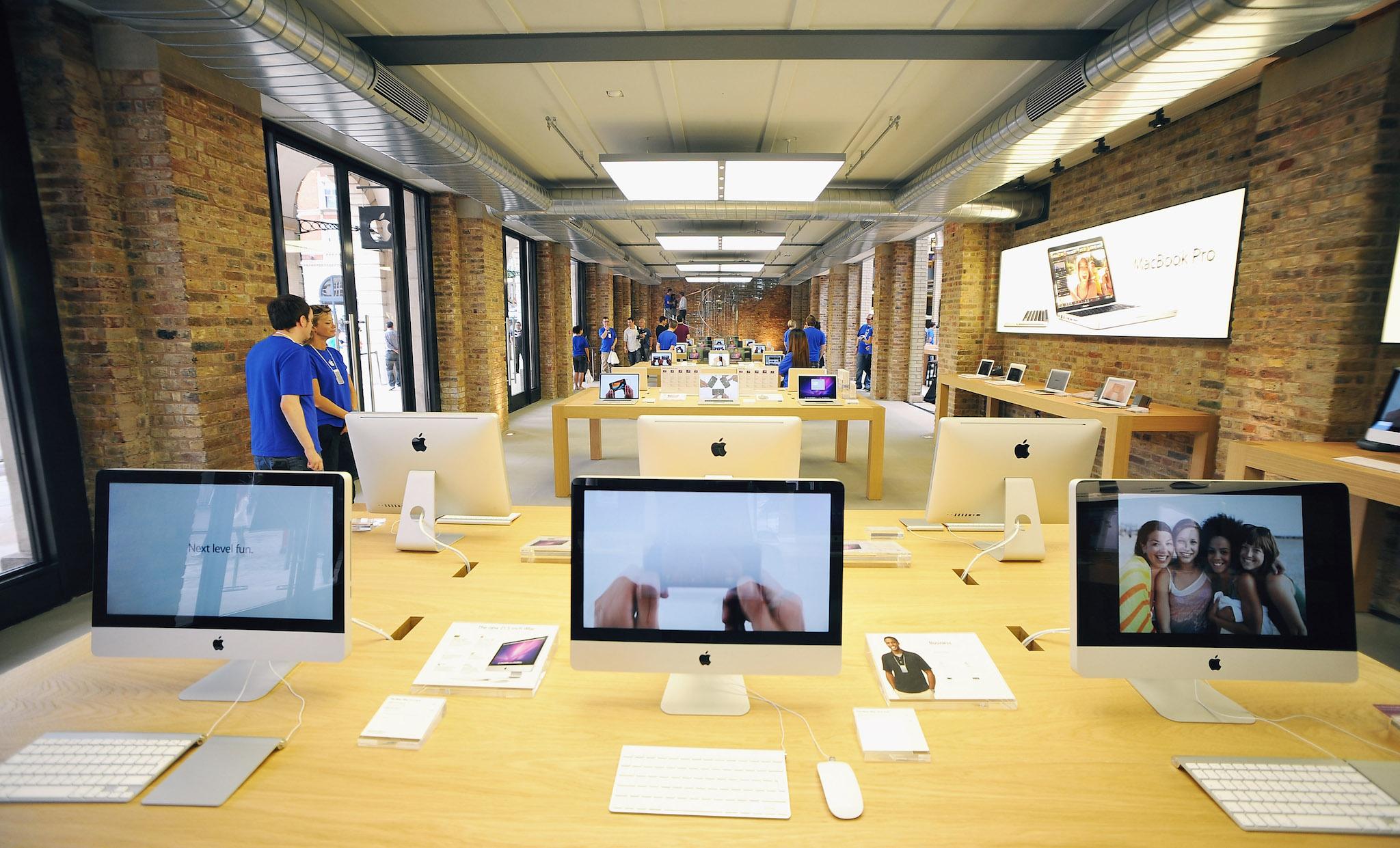 Tables of Apple Mac products on display in the Apple Store In Covent Garden