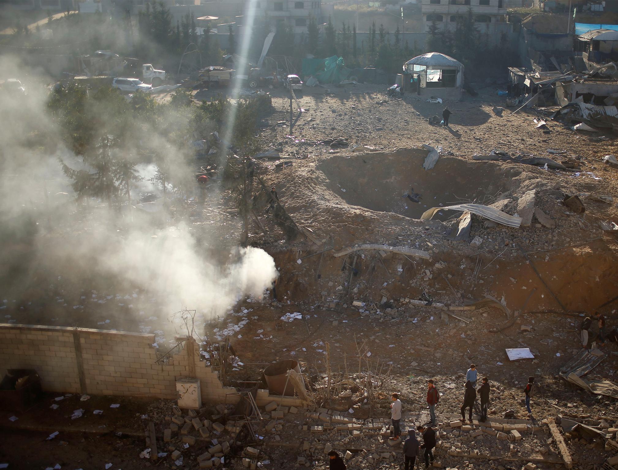 Palestinians look at a militant target that was hit in an Israeli airstrike in the northern Gaza Strip