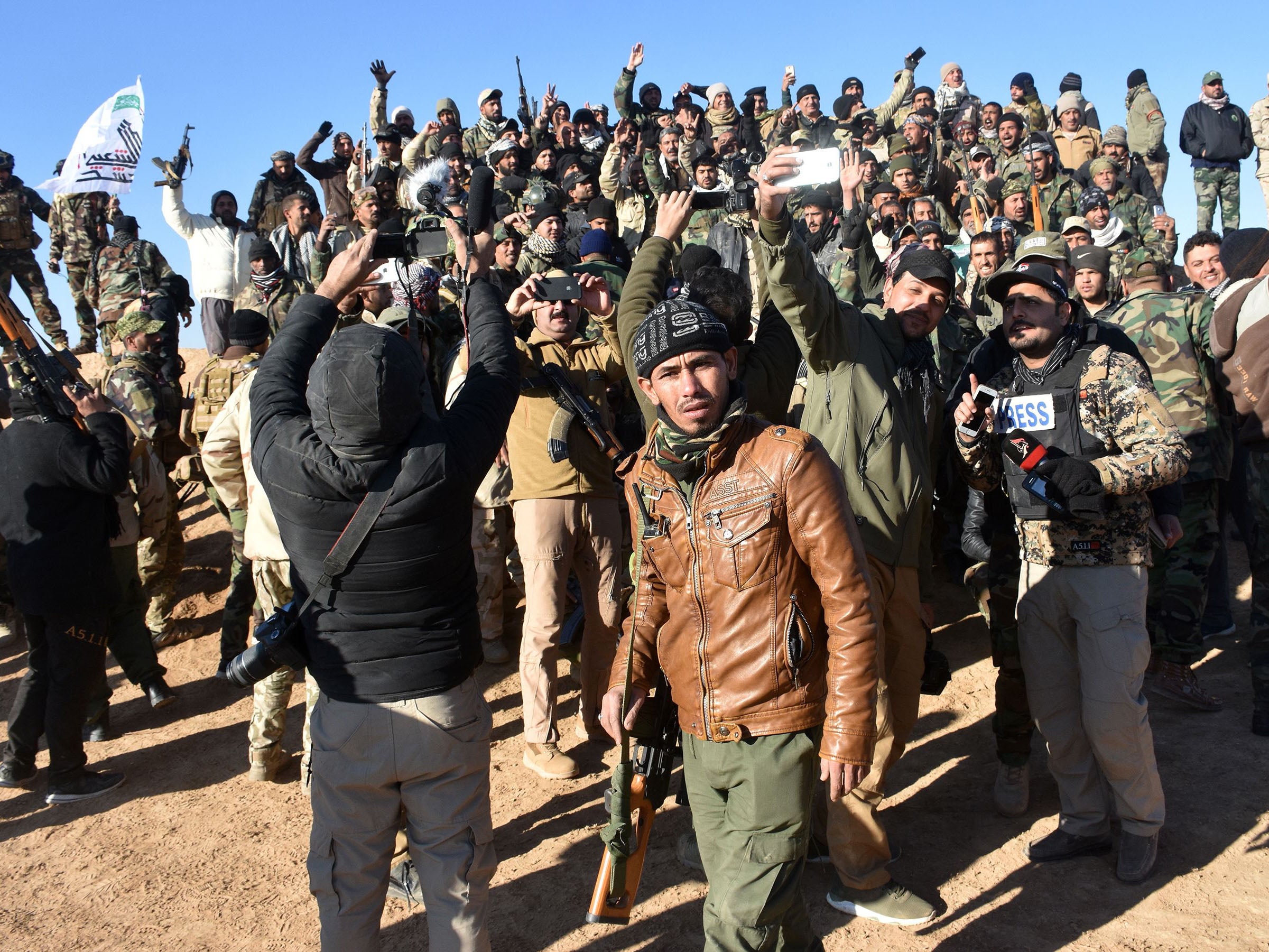 Members of the Hashed al-Shaabi celebrate yesterday after the Iraqi Prime Minister declared victory in the war against Isis