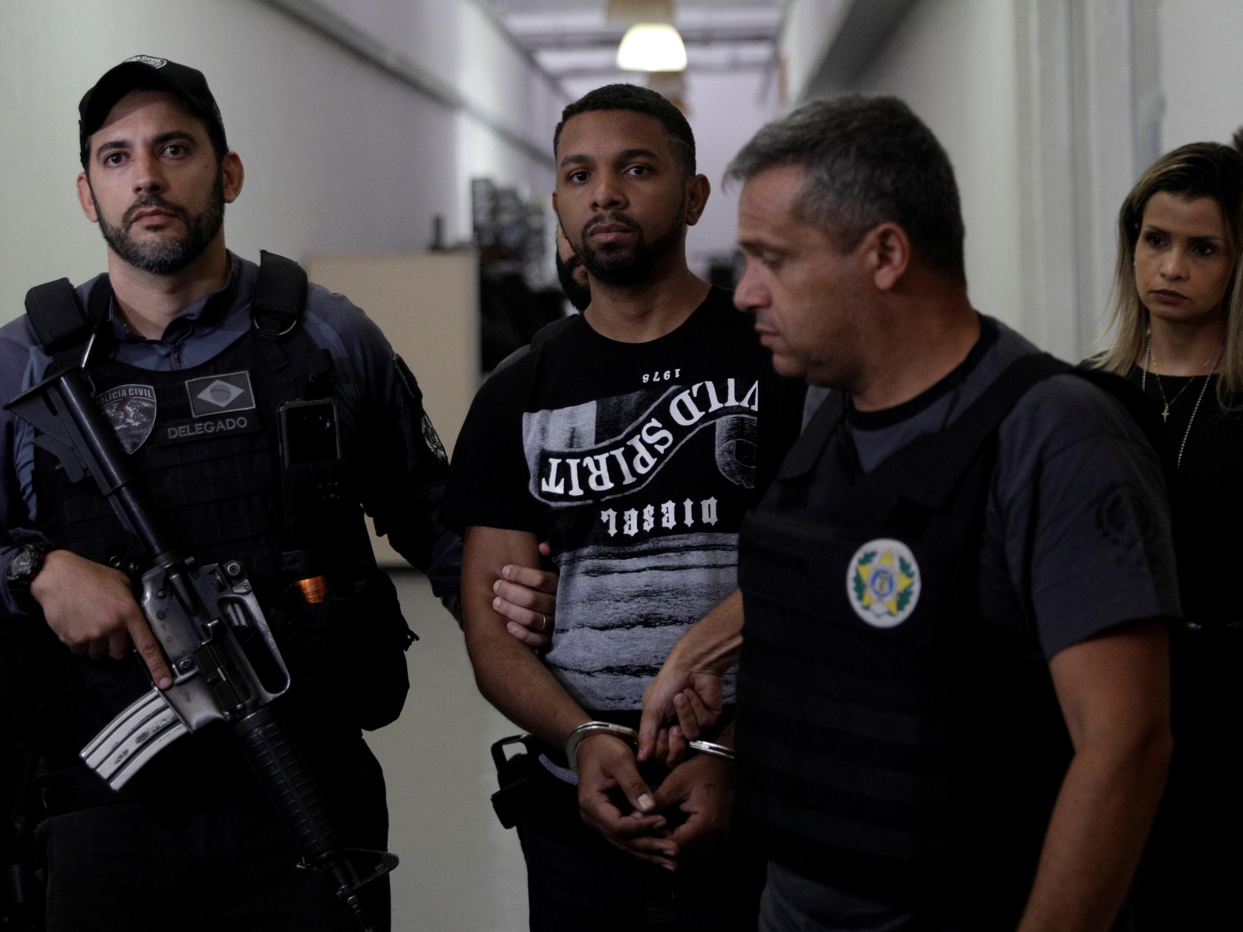 Rogerio Avelino da Silva, also known as Rogerio 157, who is accused by authorities to be the drug dealing chief of Rocinha slum, is escorted by policemen at a police station complex in Rio de Janeiro