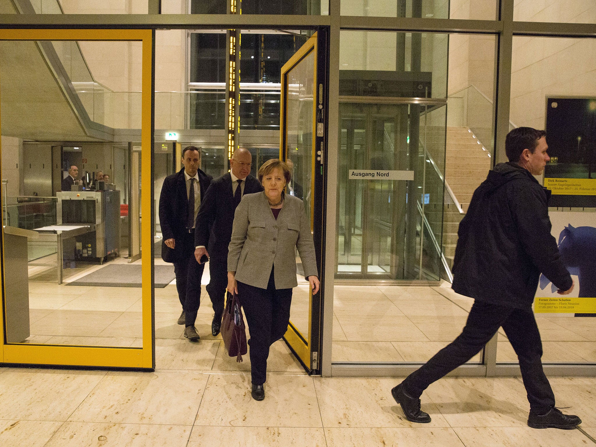 Ms Merkel arrives back in Germany at the Reichstag building in Berlin on Wednesday evening, for planned coalition talks