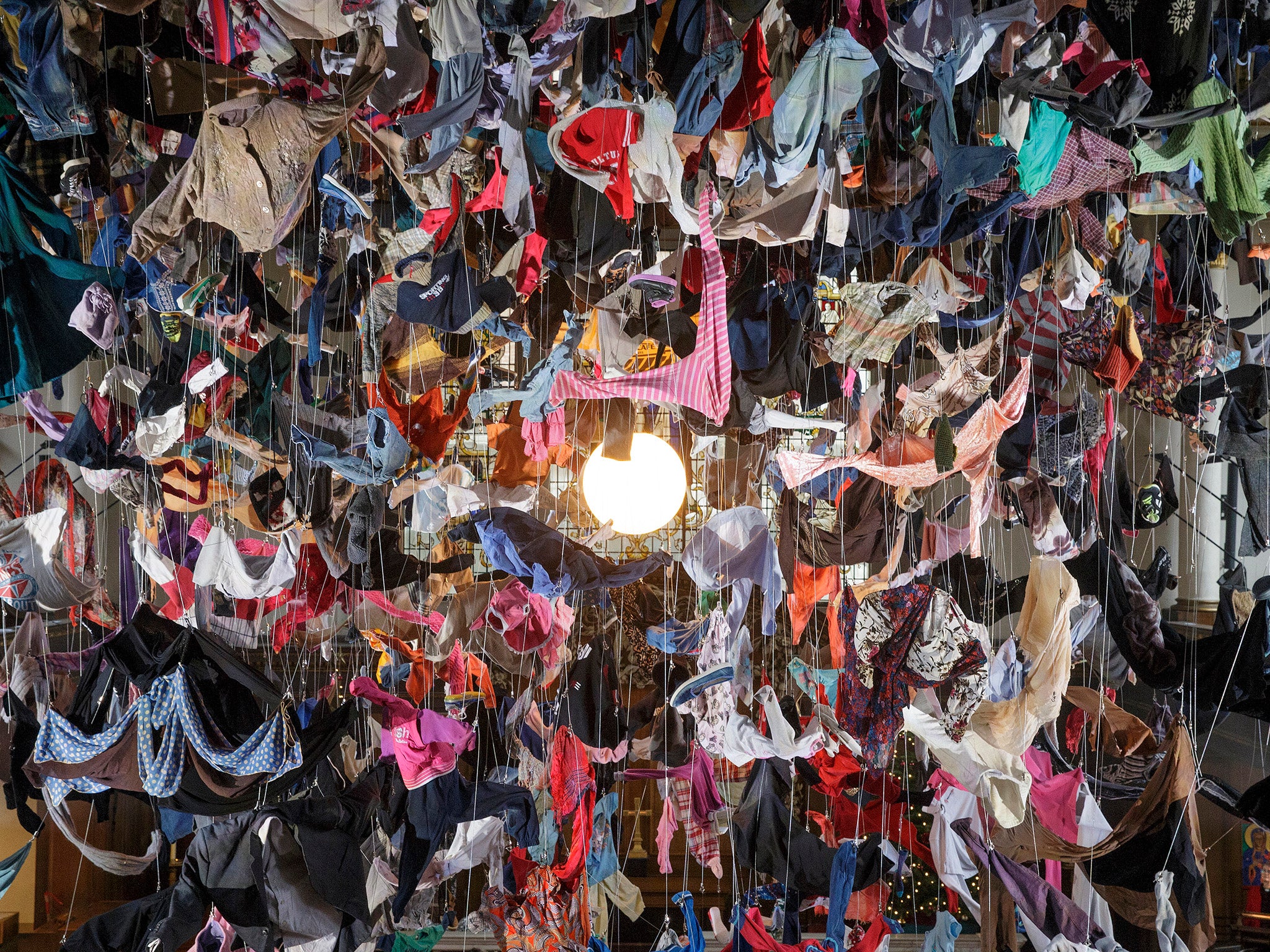 People view an installation artwork called Suspended, composed of items of clothing discarded by refugees on their arrival at Lesvos, by artist Arabella Dorman, at St James's Church on Piccadilly in London