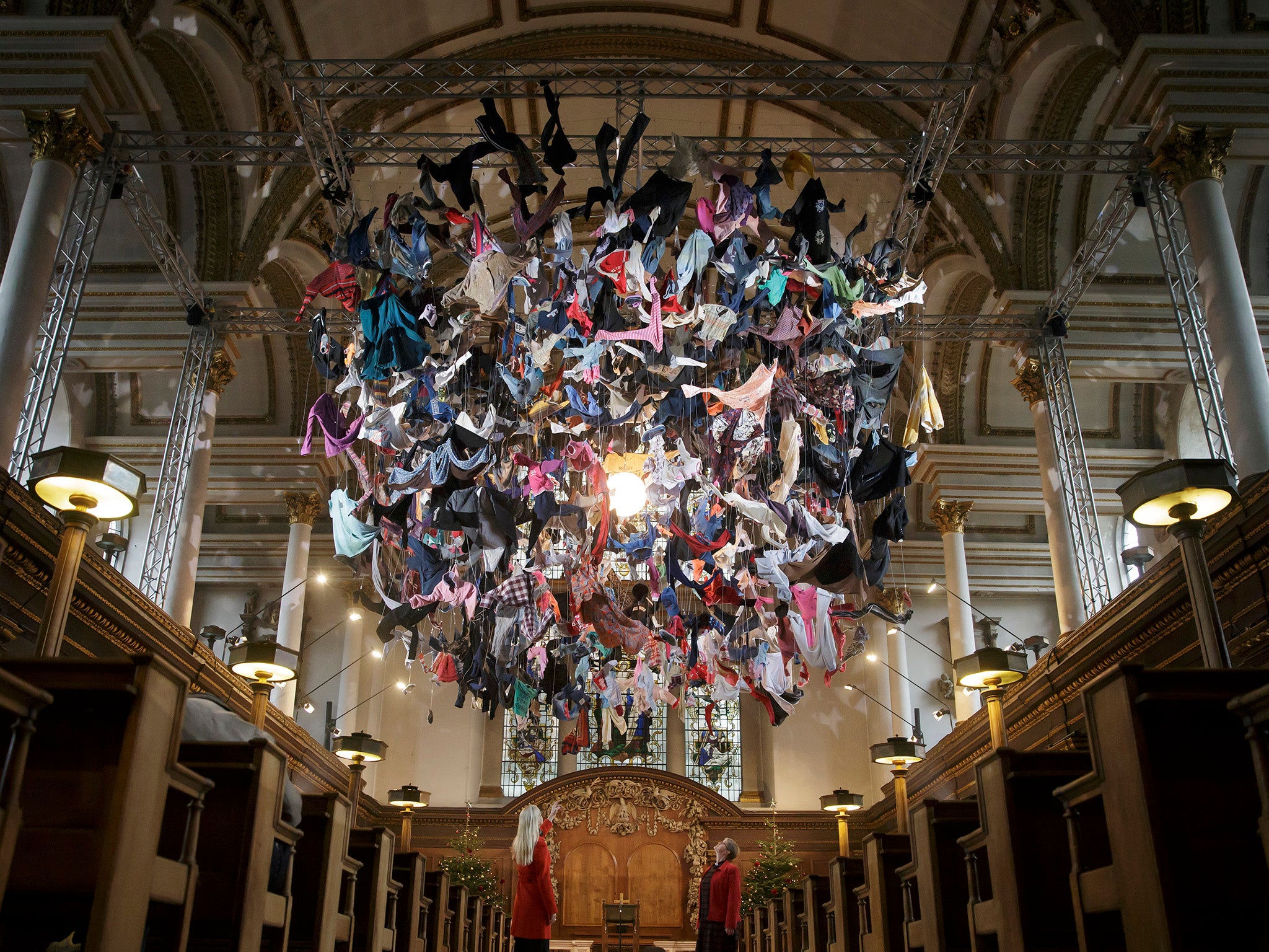 People view an installation artwork called Suspended, composed of items of clothing discarded by refugees on their arrival at Lesvos, by artist Arabella Dorman, at St James's Church on Piccadilly in London