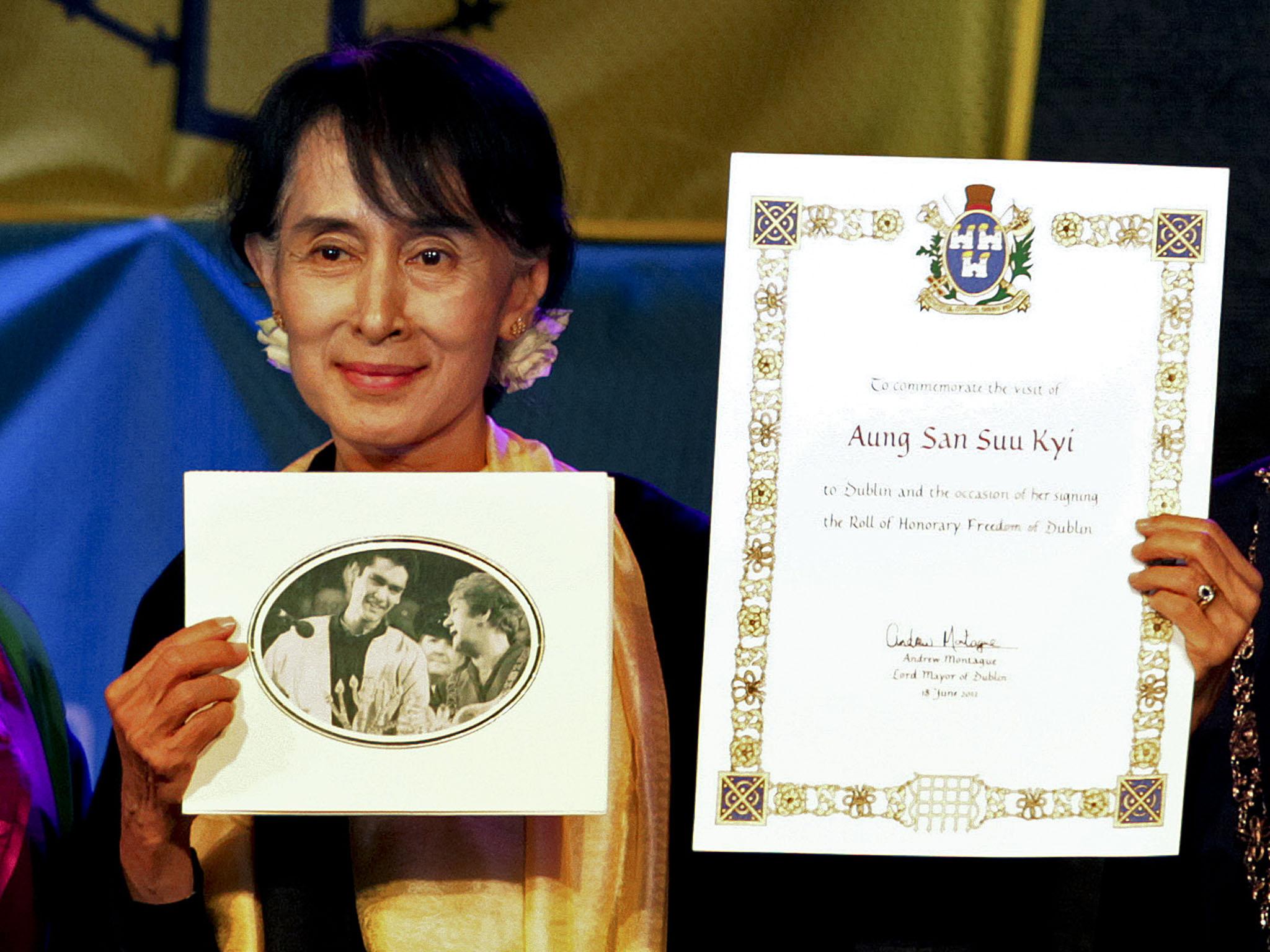 Aung San Suu Kyi holding up her freedom of the city during the ceremony in 2012 when she was finally able to collect the award