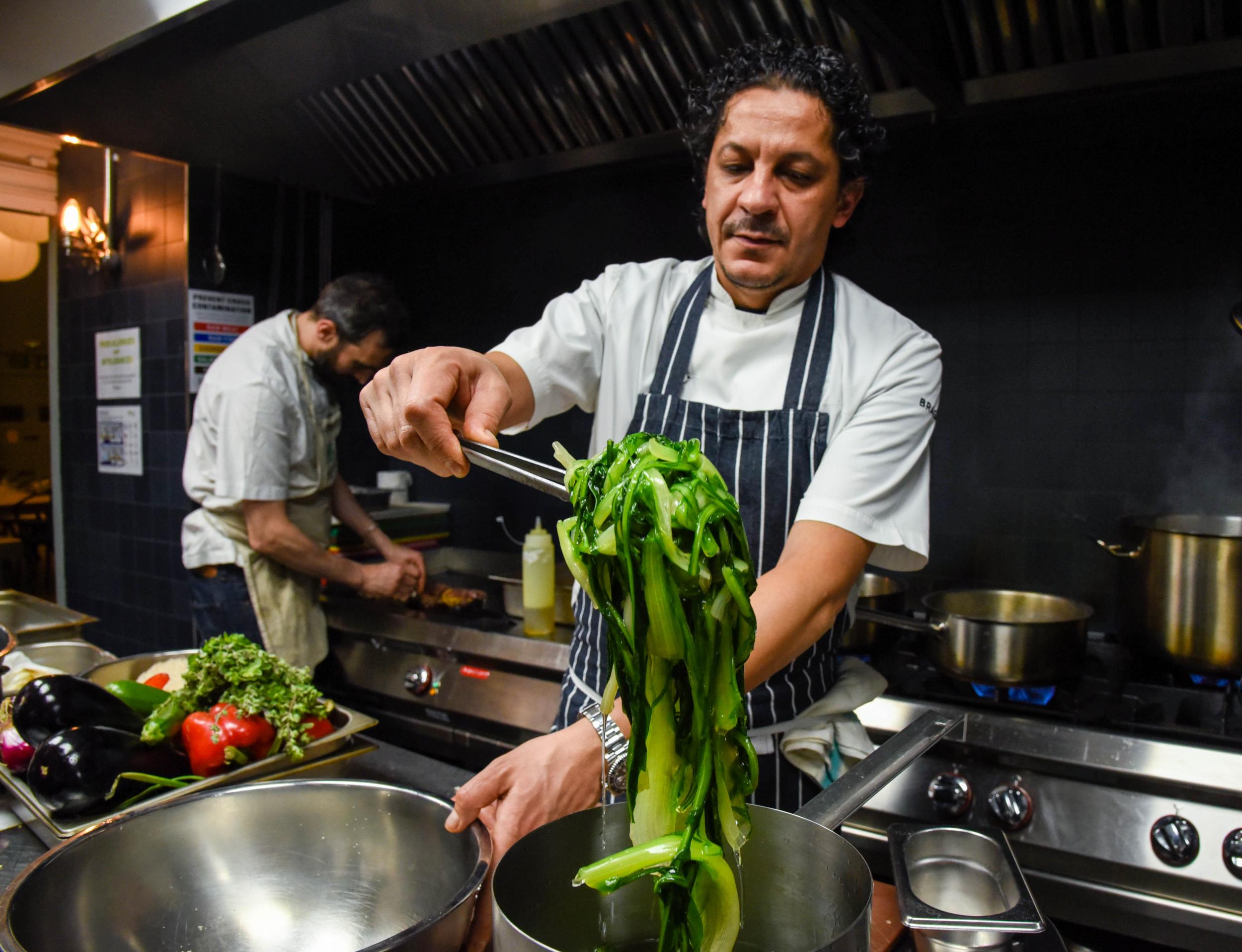 Mazzei transfers the blanched greens into ice water