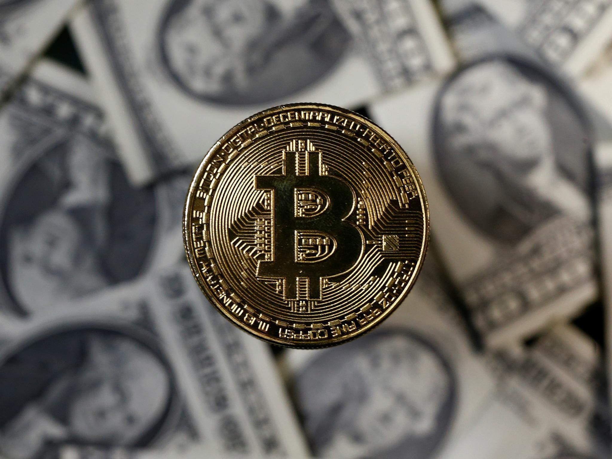 A bitcoin (virtual currency) coin placed on Dollar banknotes is seen in this illustration picture, November 6, 2017