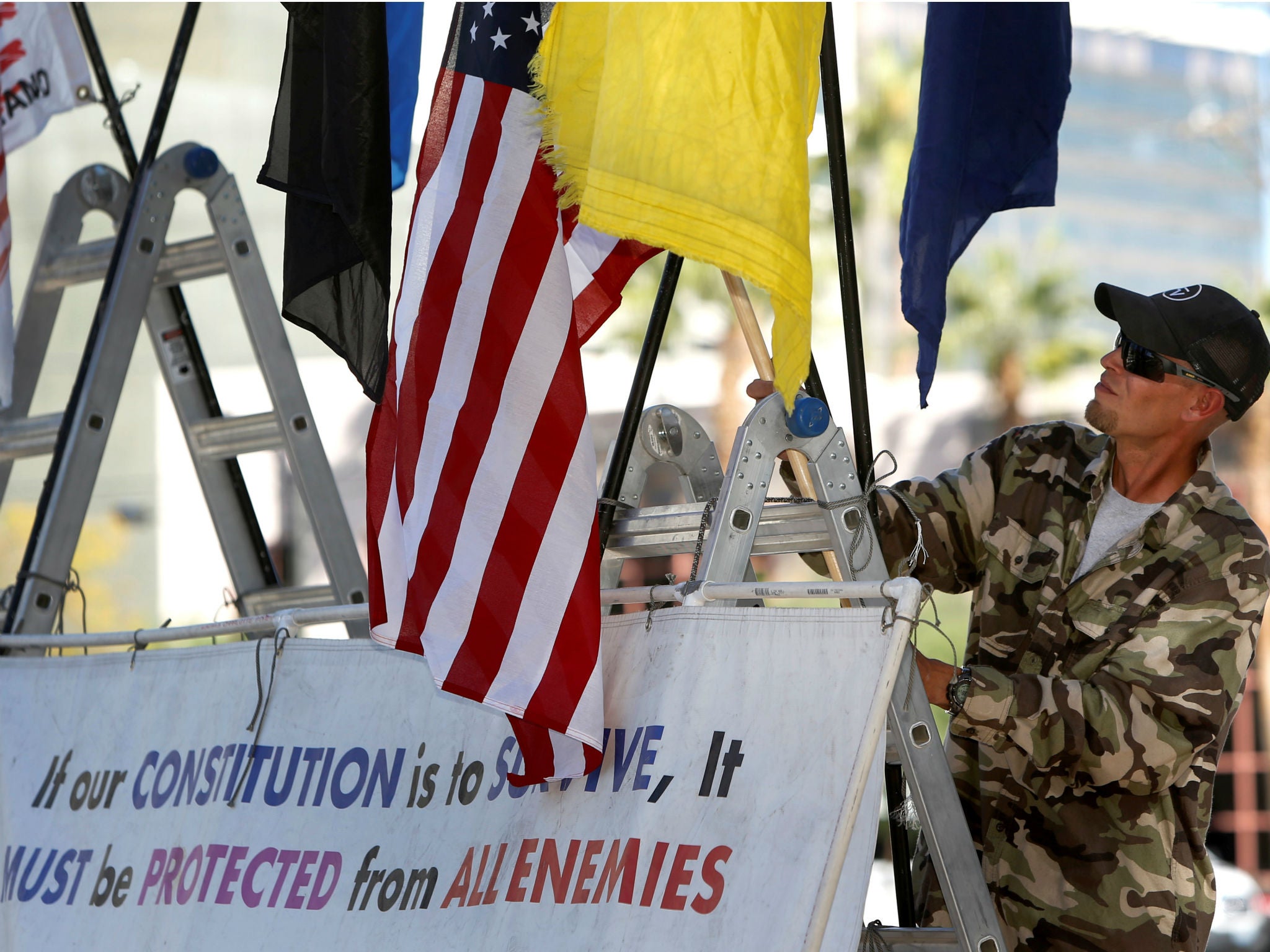 A supporter of Nevada rancher Cliven Bundy and his family attaches a flag to a sign outside the federal courthouse in Las Vegas, Nevada