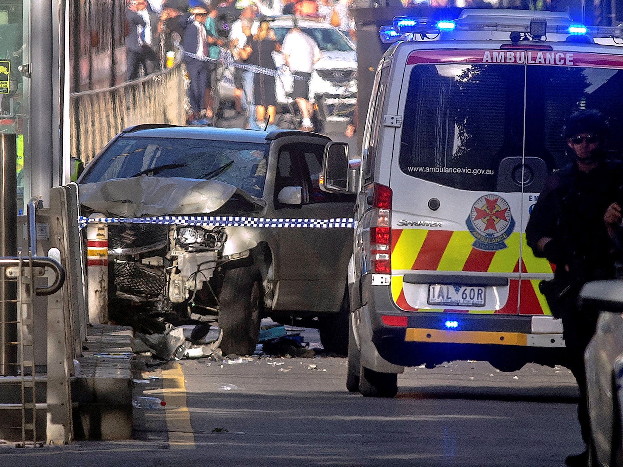 Police and emergency personnel work at the scene of where a car ran over pedestrians in Flinders Street in Melbourne