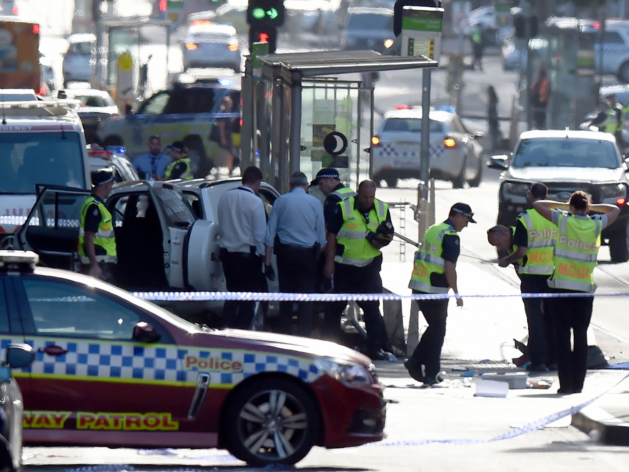 Police and emergency personnel work at the scene of where a car ran over pedestrians in Flinders Street in Melbourne