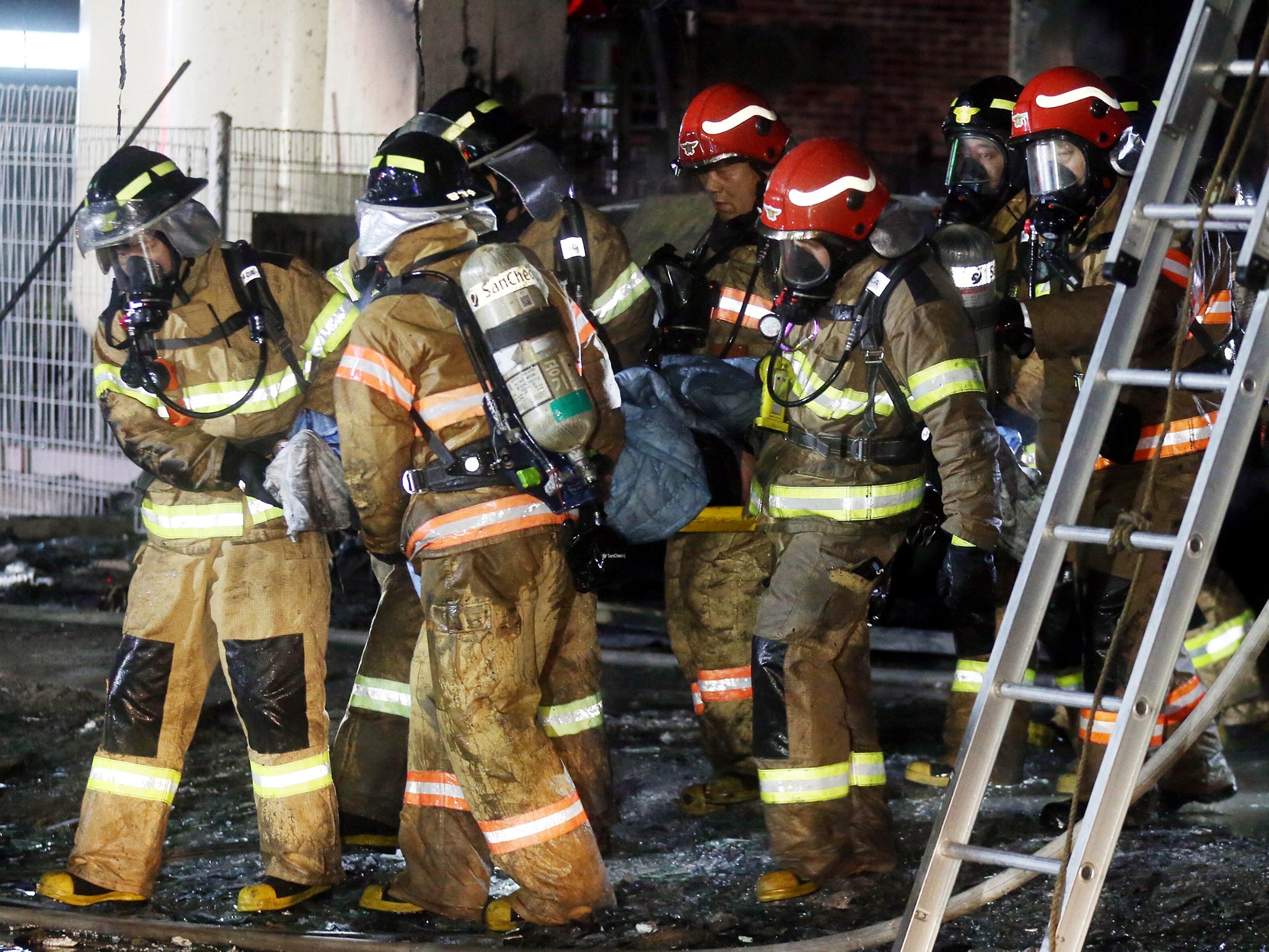 A victim is carried by firefighters