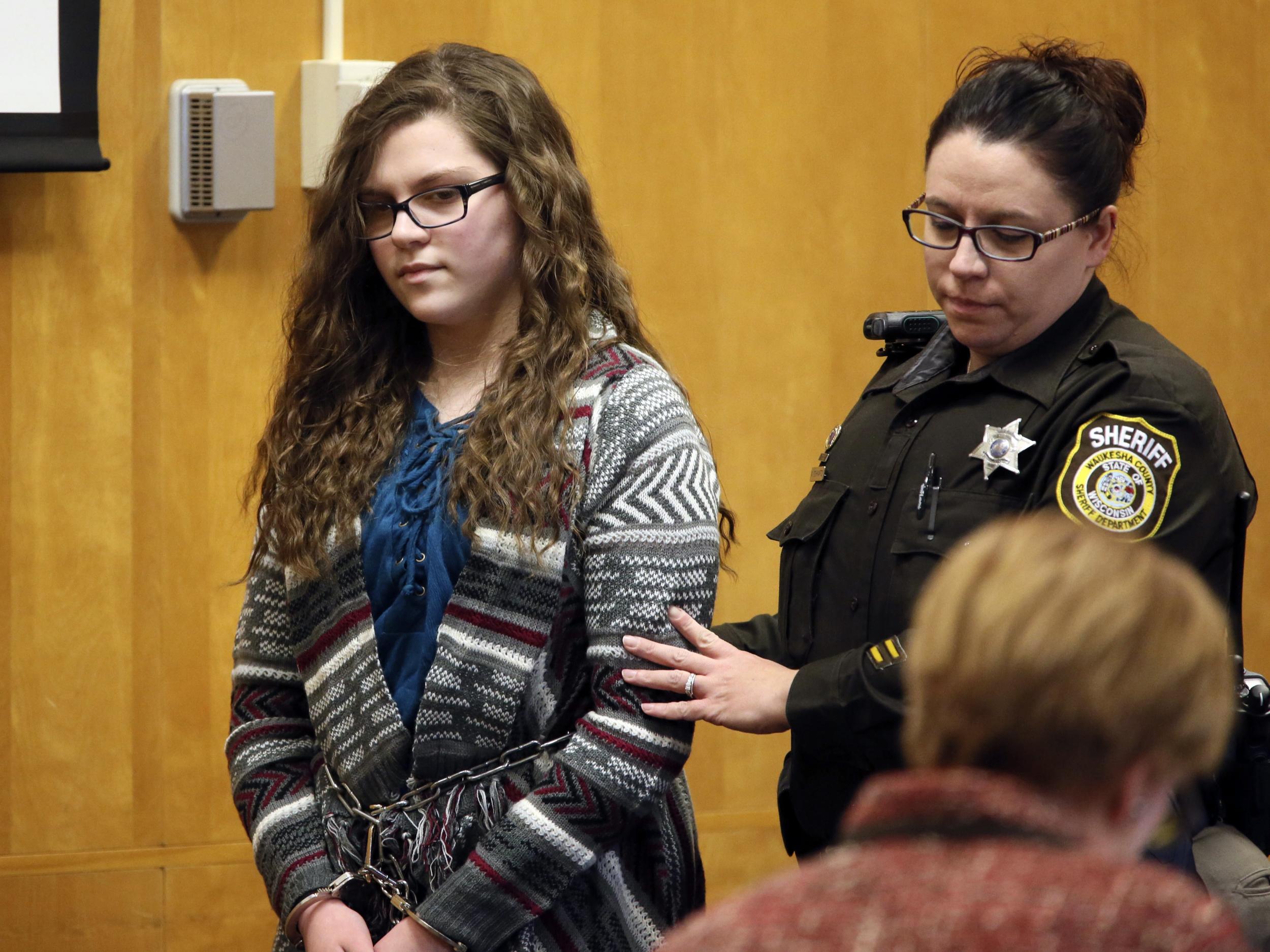 Anissa Weier, one of two Wisconsin girls who tried to kill a classmate to win favour with a fictional horror character named Slender Man, is led into the Waukesha County Court for her sentencing hearing