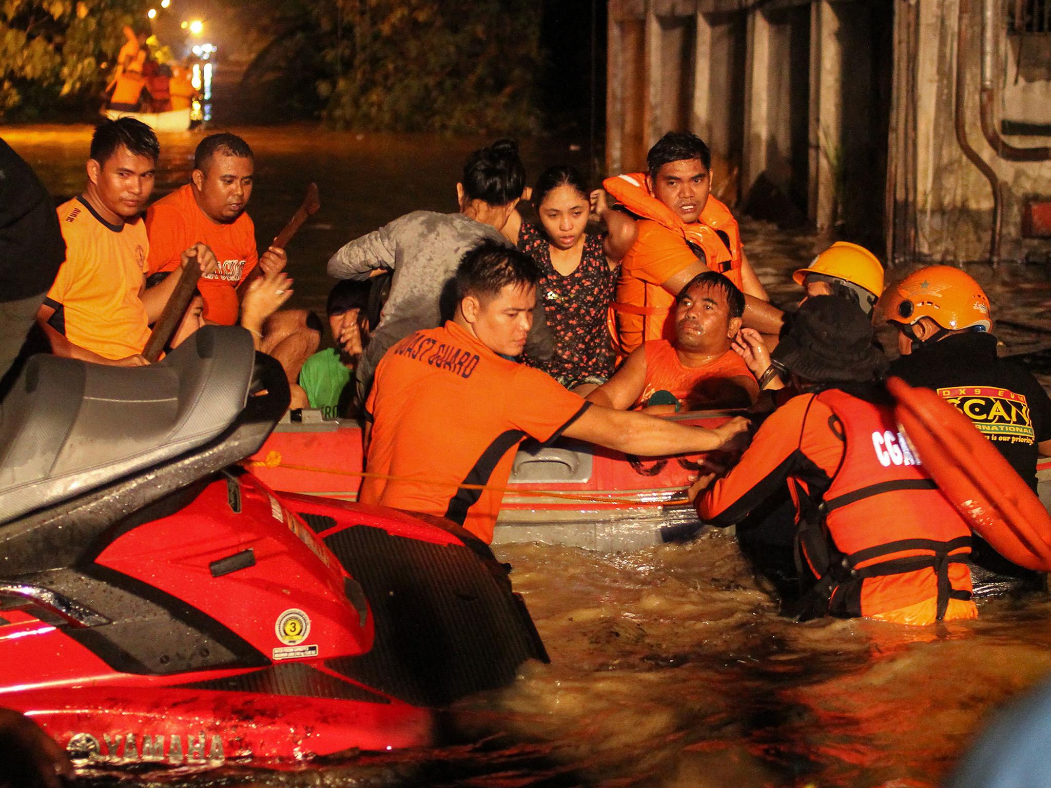 Rescue workers evacuate flood-affected residents in Davao on the southern Philippine island of Mindanao after Tropical Storm Tembin dumped torrential rains across the island